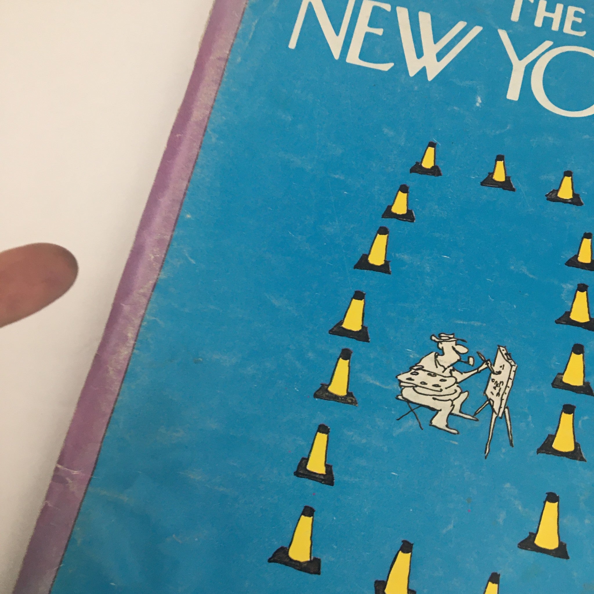Close-up view of the cover of The New Yorker Magazine, October 10, 1977, highlighting the title 'Artists & Traffic Cones' by Arnie Levin, with a cartoon artist painting amidst yellow traffic cones.