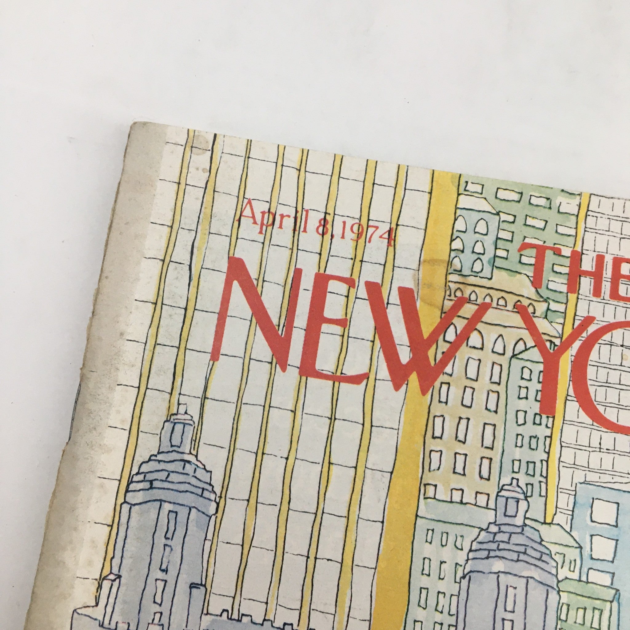 Close-up of the cover of The New Yorker Magazine April 8 1974, showcasing the title and colorful illustration of urban architecture, emphasizing the magazine's focus on tall buildings.