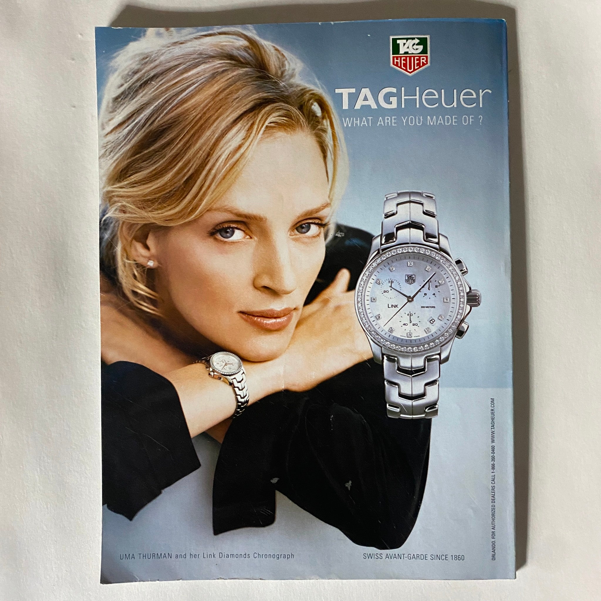 Elle Magazine January 2006 Scarlett Johansson Cover displaying a TAG Heuer advertisement featuring Uma Thurman wearing a diamond chronograph watch, emphasizing luxury and style.