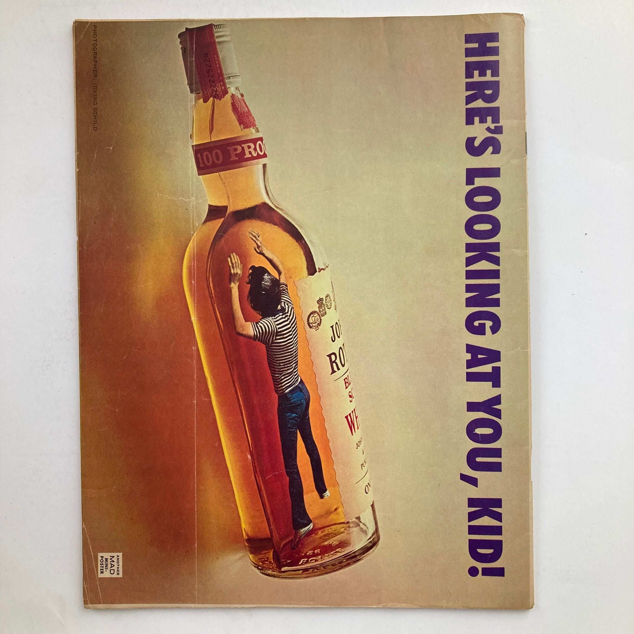 Back cover of Mad Magazine October 1975 No. 178, showcasing a whimsical illustration of a man inside a whiskey bottle with the caption 'Here's Looking at You, Kid!' This vintage magazine reflects the humor and satire of its time.