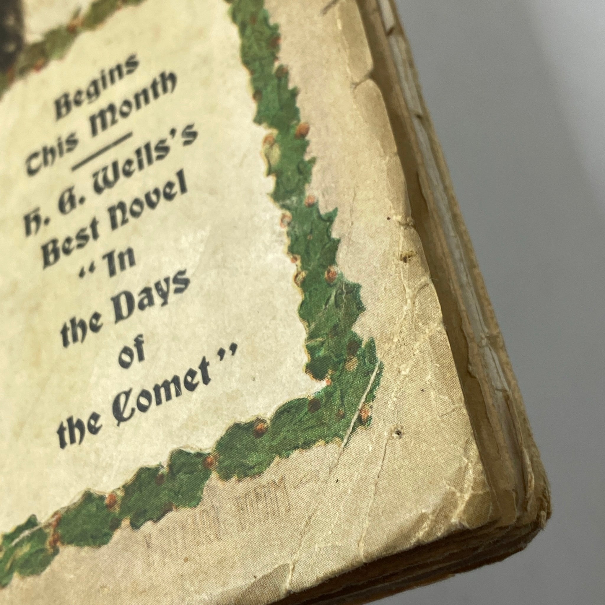 Close-up of the vintage Cosmopolitan Magazine December 1905 cover, highlighting festive decorations and text related to H. G. Wells's novel 'In the Days of the Comet'.