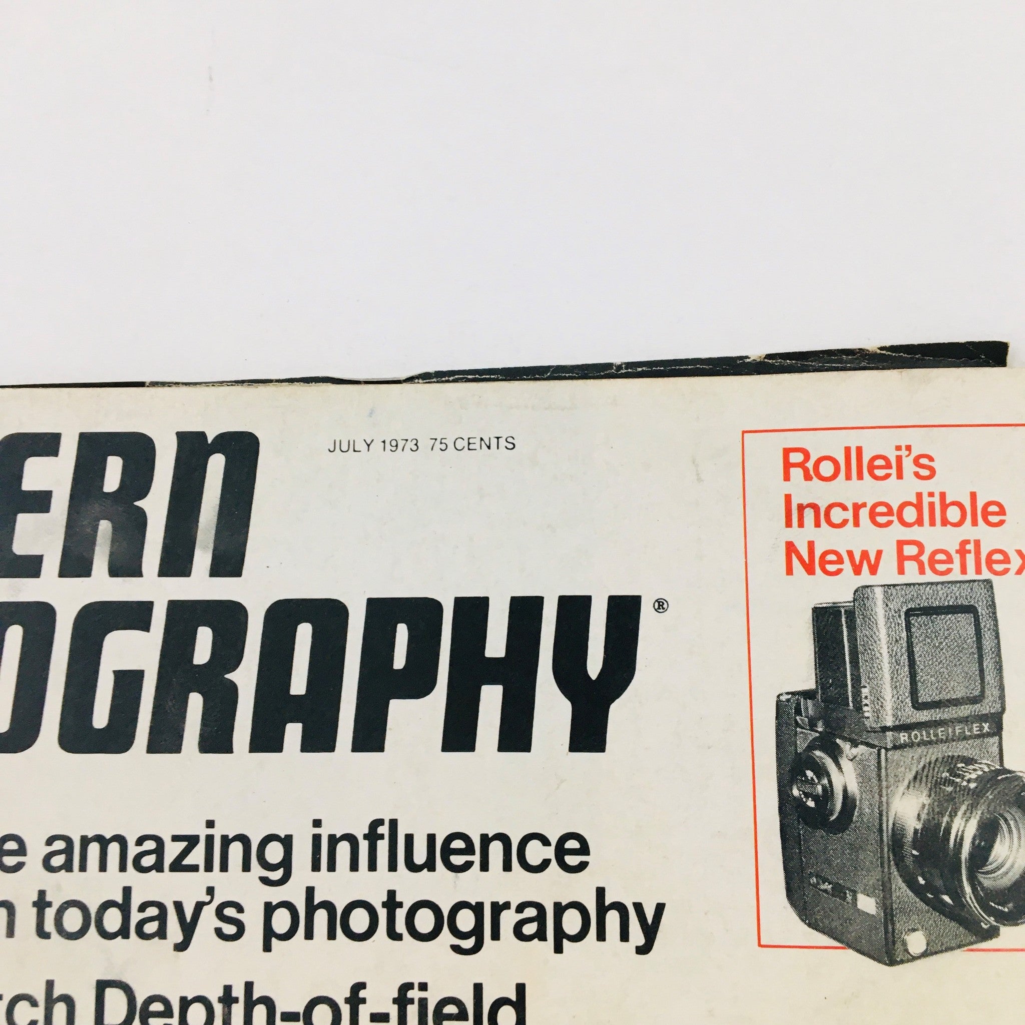 Close-up of the cover of Modern Photography Magazine July 1973 highlighting the title and an advertisement for Rolleiflex cameras, showcasing photography tips.
