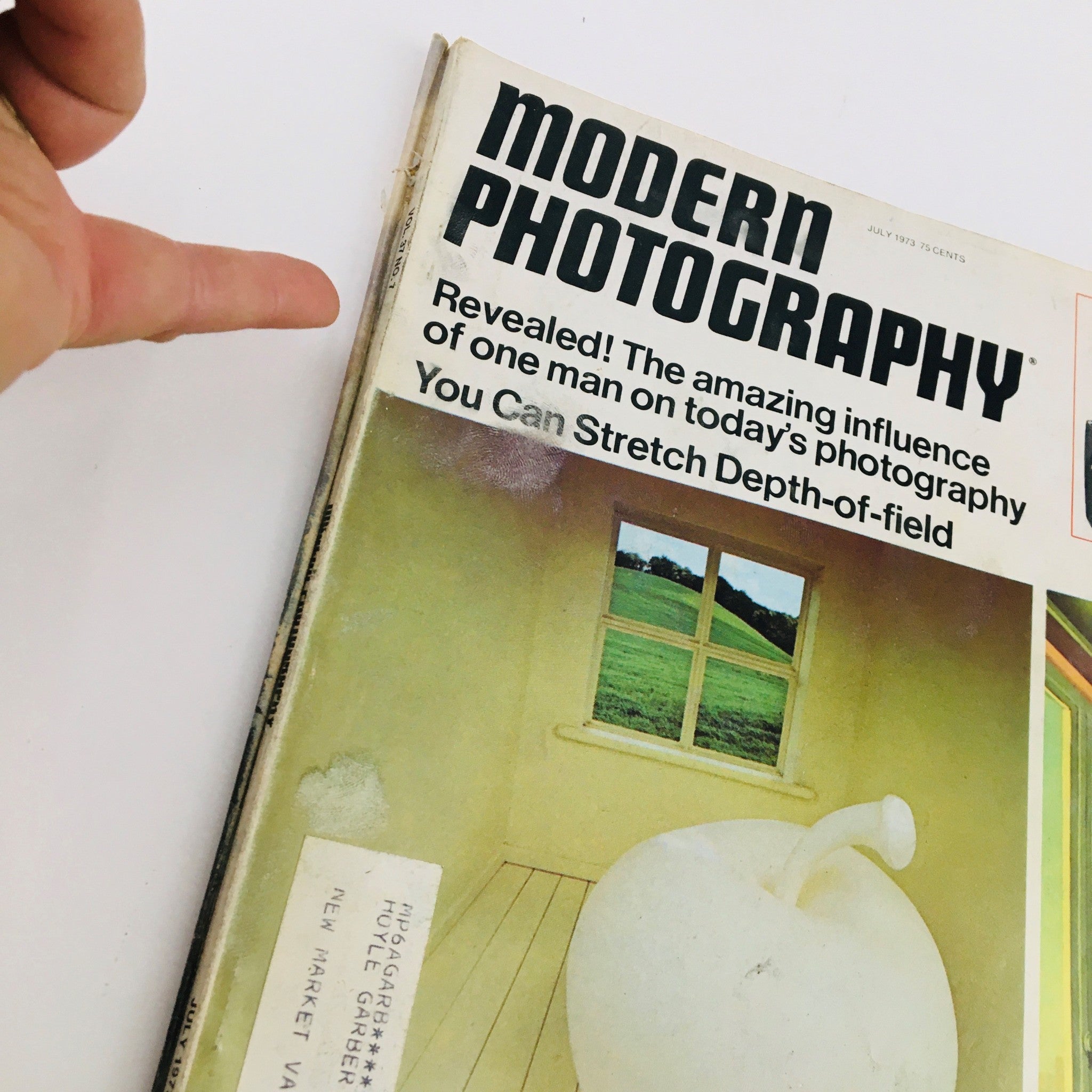 Side view of Modern Photography Magazine July 1973, demonstrating the magazine's title and design, along with a glimpse of the address label on the cover.