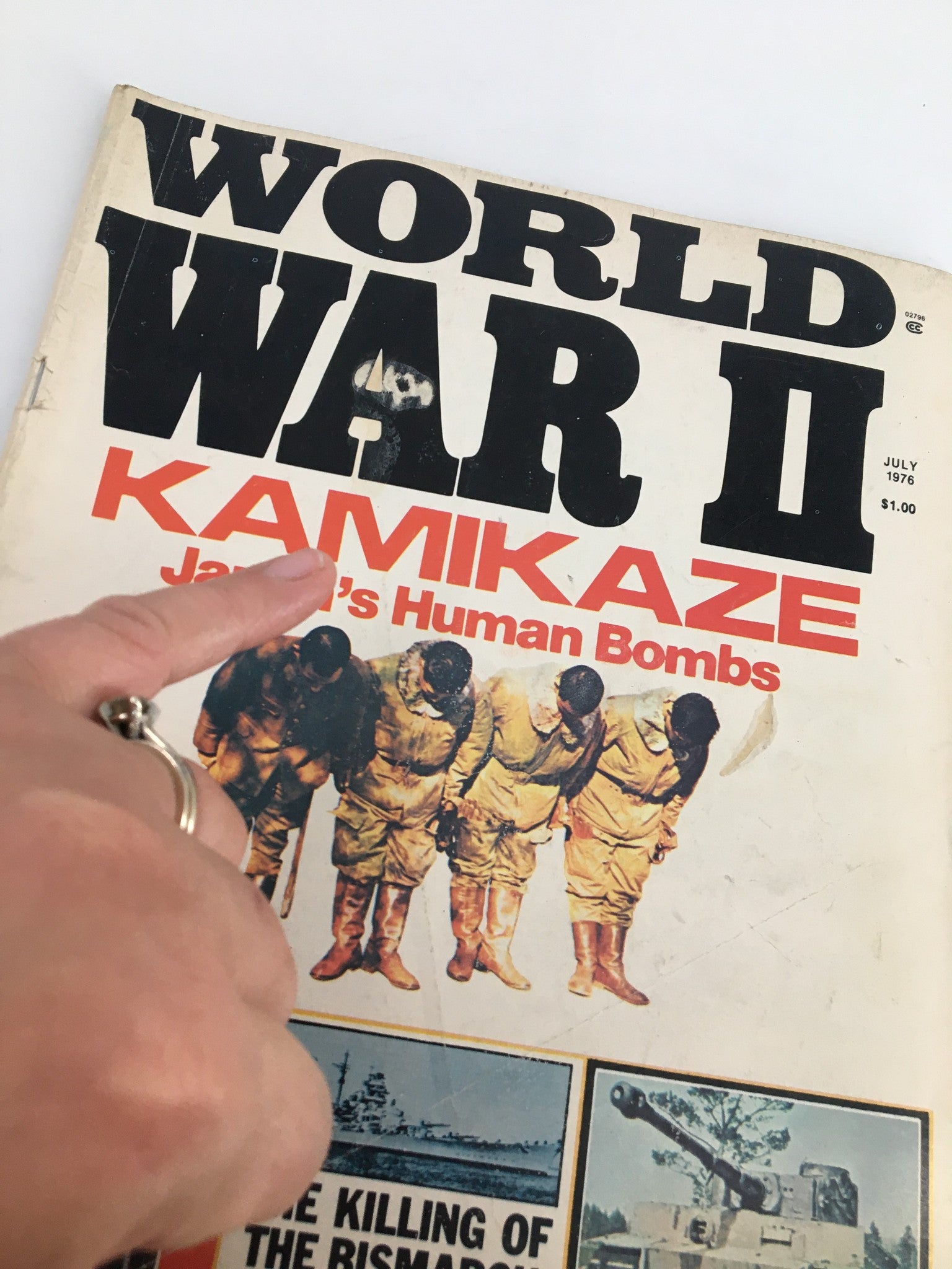 Close-up view of VTG World War II Magazine July 1976 cover highlighting 'Kamikaze Japan's Human Bombs' with finger pointing to significant content.