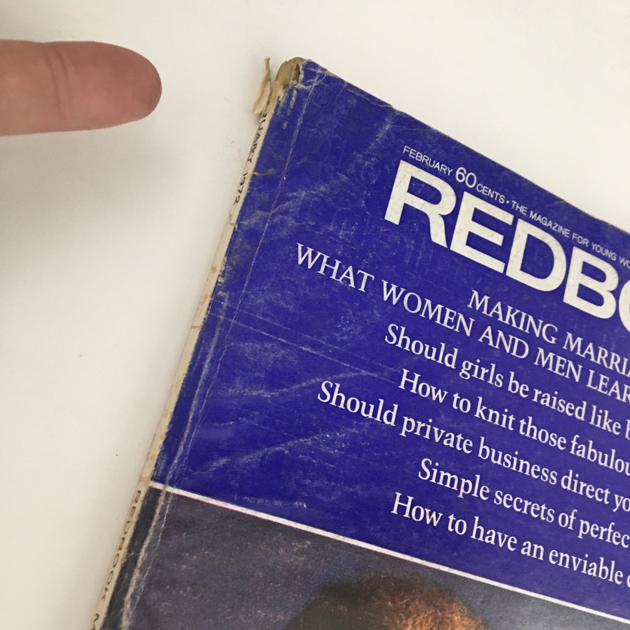 Detailed view of the spine of Redbook Magazine February 1972, showcasing wear and tear, with title and featured topics visible.