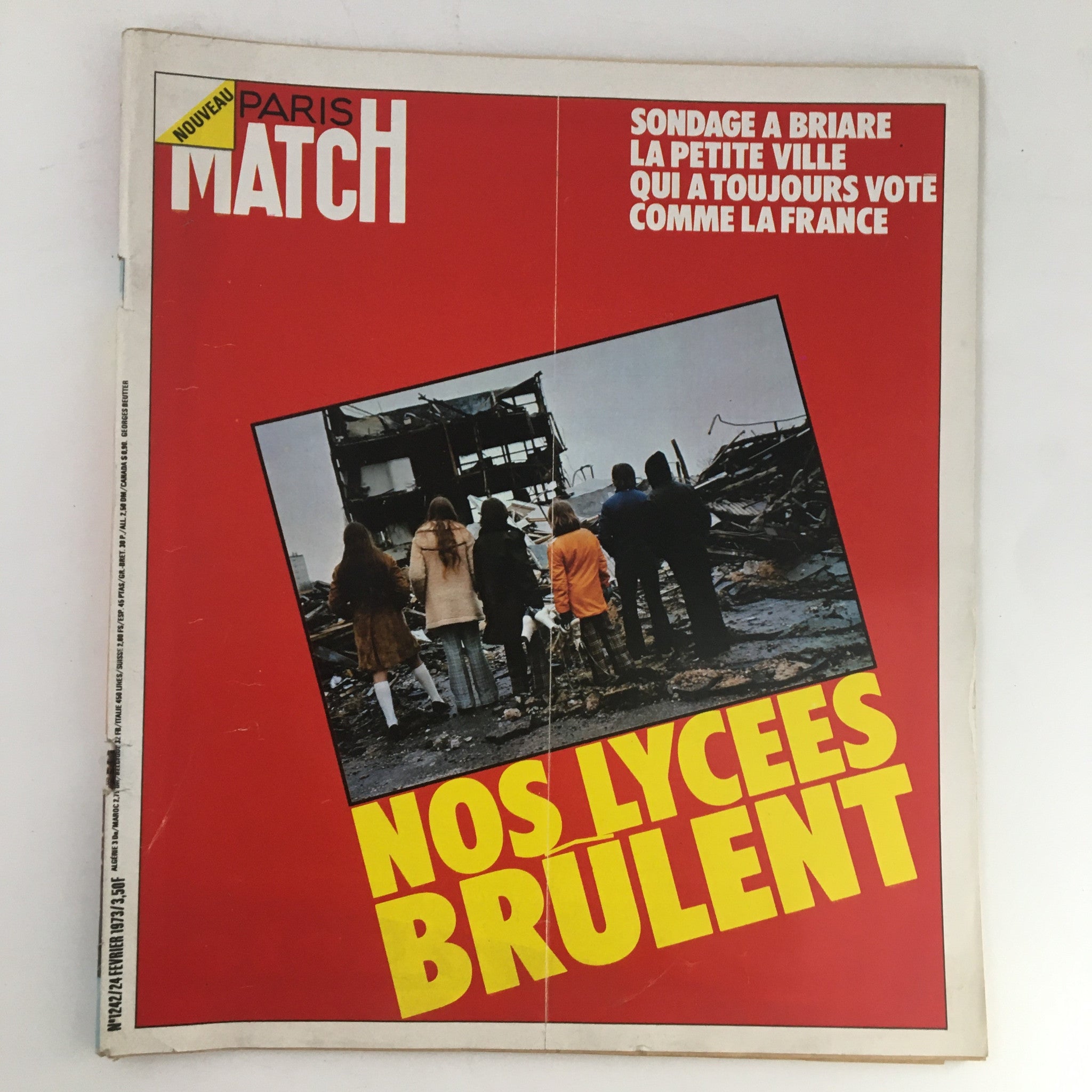 Cover of Paris Match Magazine February 1973 featuring the title 'Sondage A Briare Nos Lycees Brulent'. The image displays a group of people observing damaged buildings, emphasizing the article's focus on the social issues in Briare.
