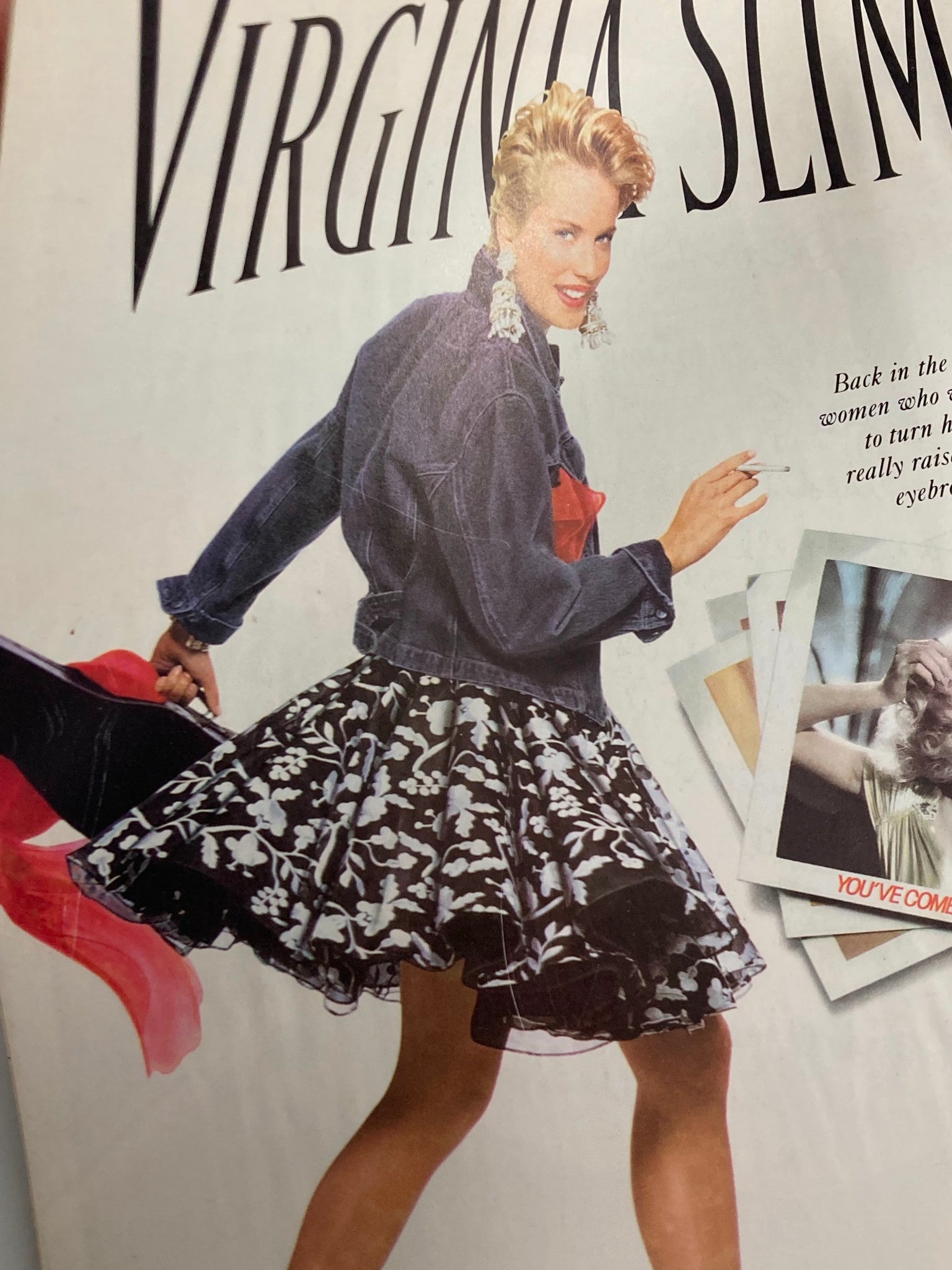 Ad from Virginia Slims showcasing a fashionable woman in a denim jacket and floral skirt, promoting 1990s style and lifestyle, included in a vintage magazine.