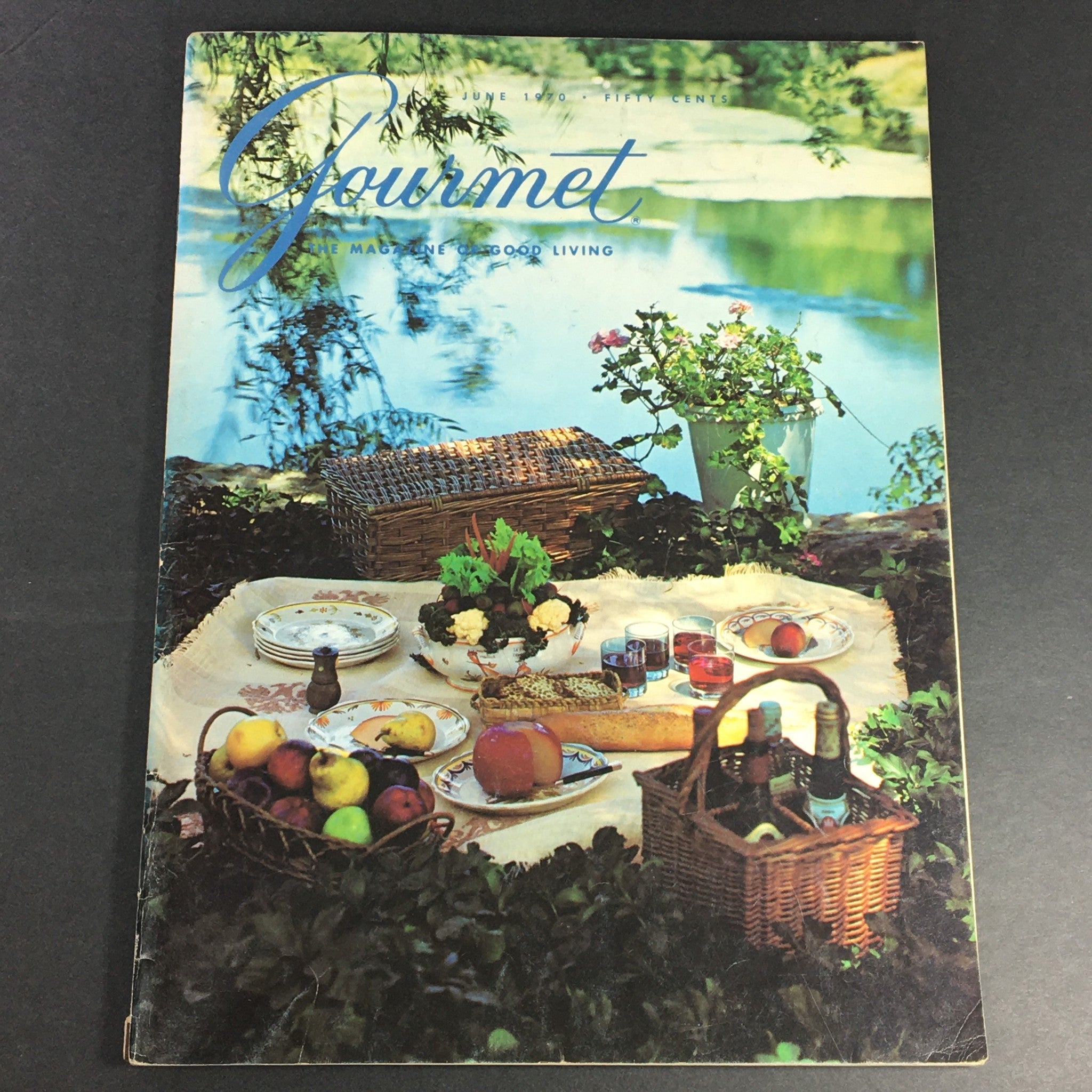 Vintage cover of VTG Gourmet The Magazine of Good Living, June 1970 edition featuring a scenic picnic setting by a lake with food and drinks laid out, highlighting the essence of leisure and culinary enjoyment.