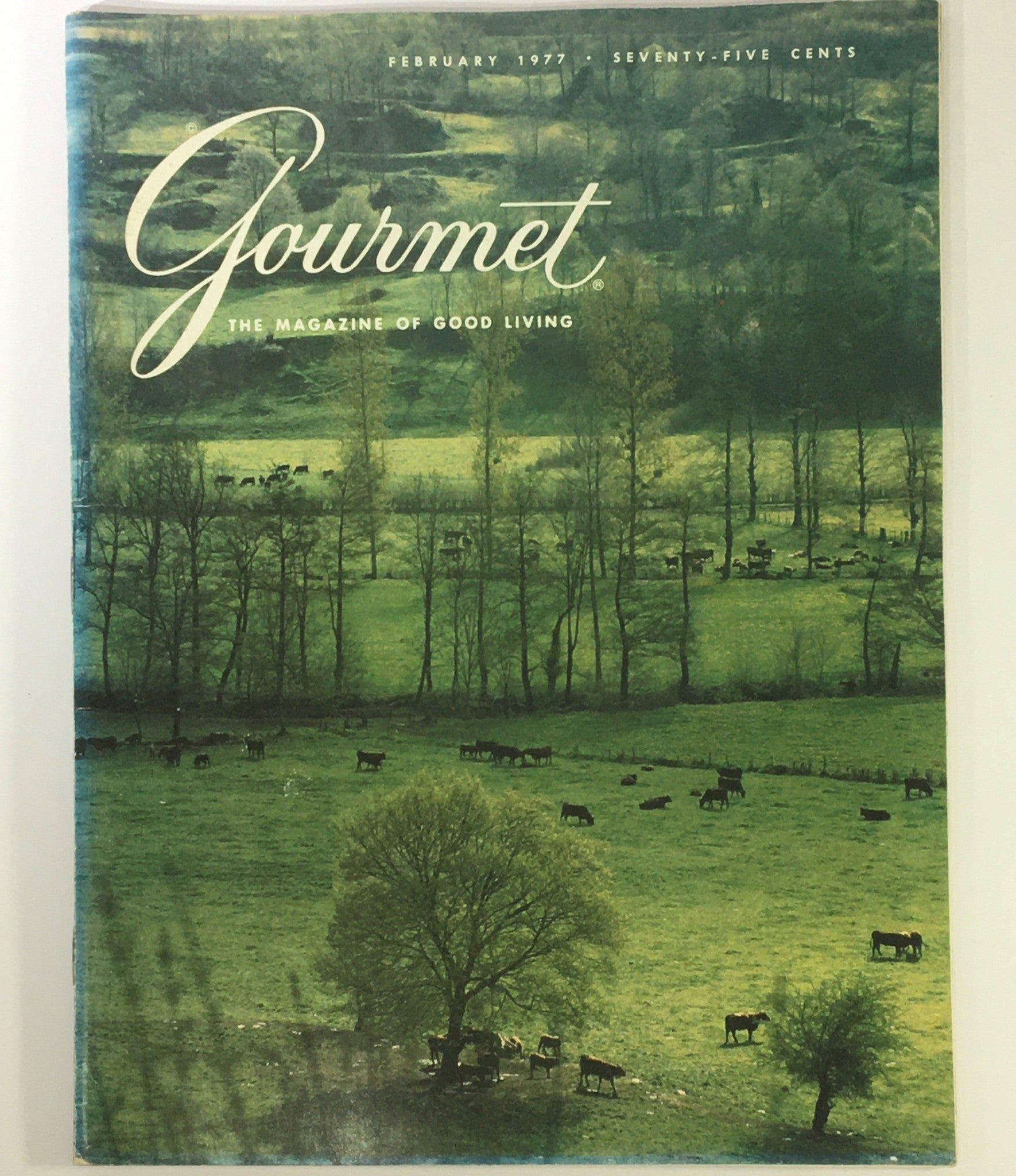 Cover of VTG Gourmet The Magazine of Good Living February 1977 showcasing a serene landscape with grazing cows and lush greenery.