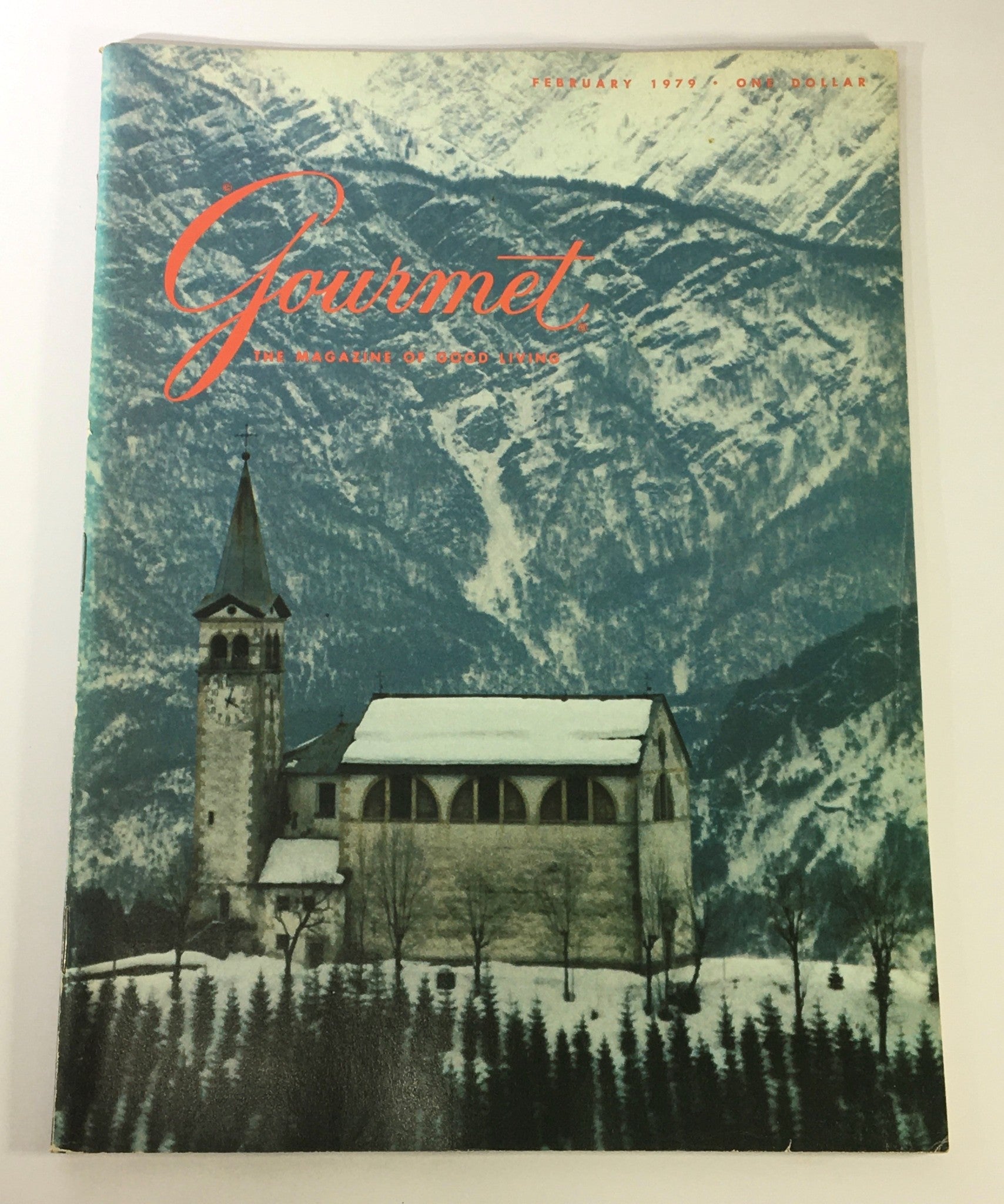 Cover of VTG Gourmet: The Magazine of Good Living February 1979 - A Mint of an Idea, featuring a picturesque snowy mountain landscape and a historic building with a clock tower.