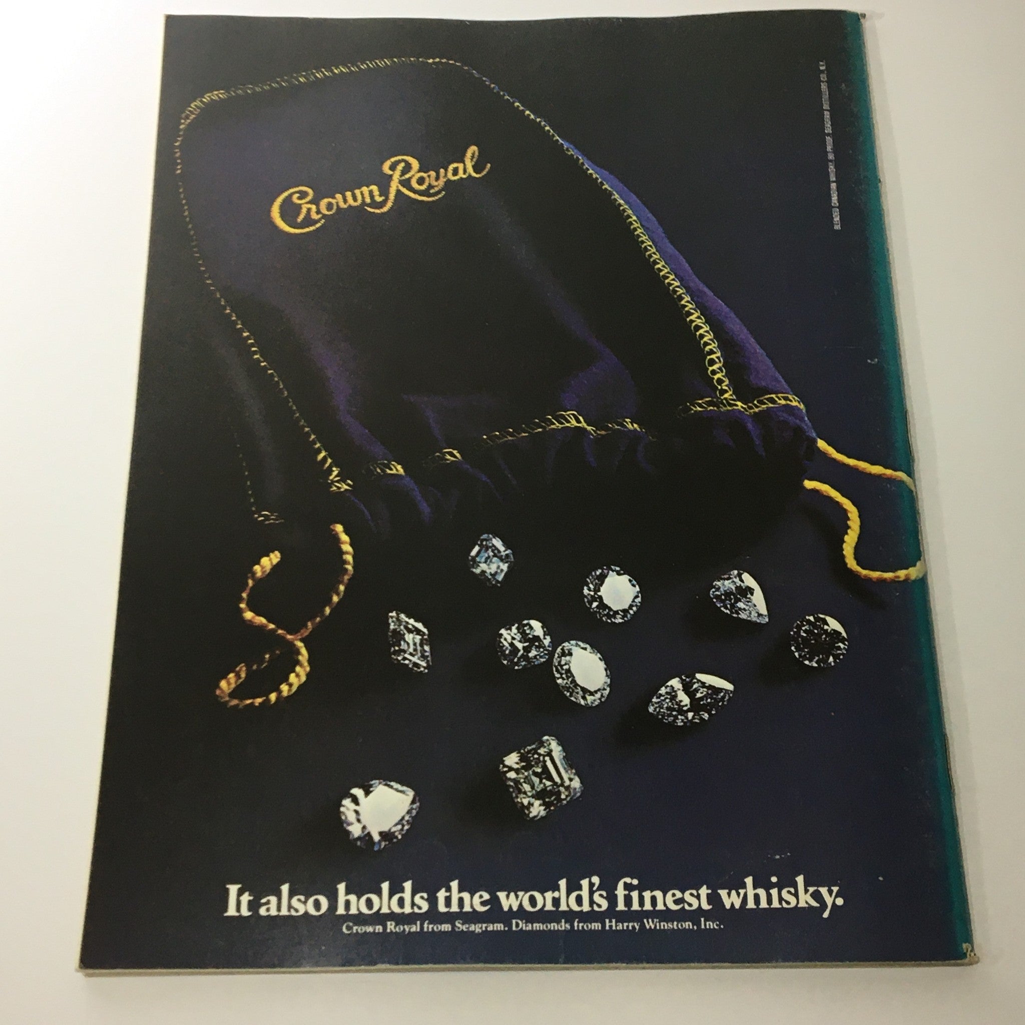 Advertisement in VTG Gourmet Magazine August 1979 for Crown Royal, featuring a purple bag and faceted crystals, emphasizing luxury and fine whisky.