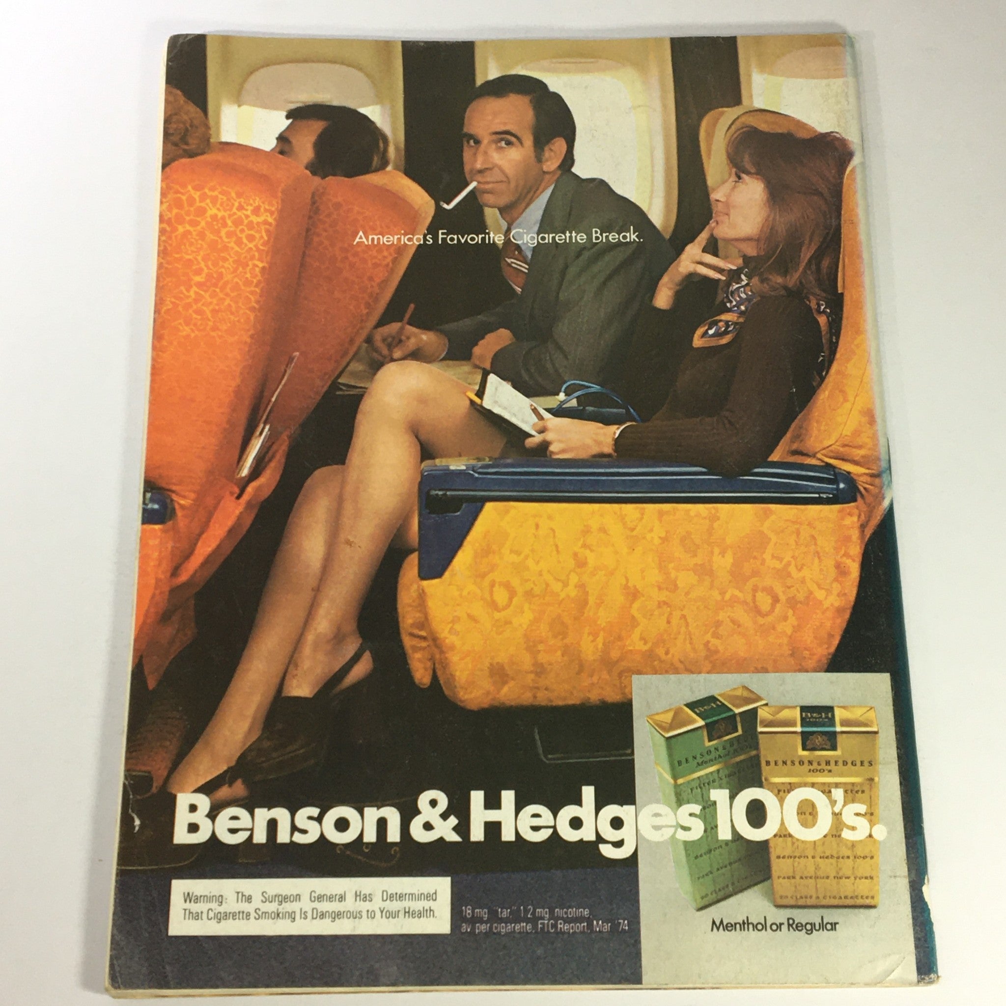 Vintage advertisement from October 1974 magazine, featuring a scene of passengers on an airplane with the tagline 'America's Favorite Cigarette Break'.
