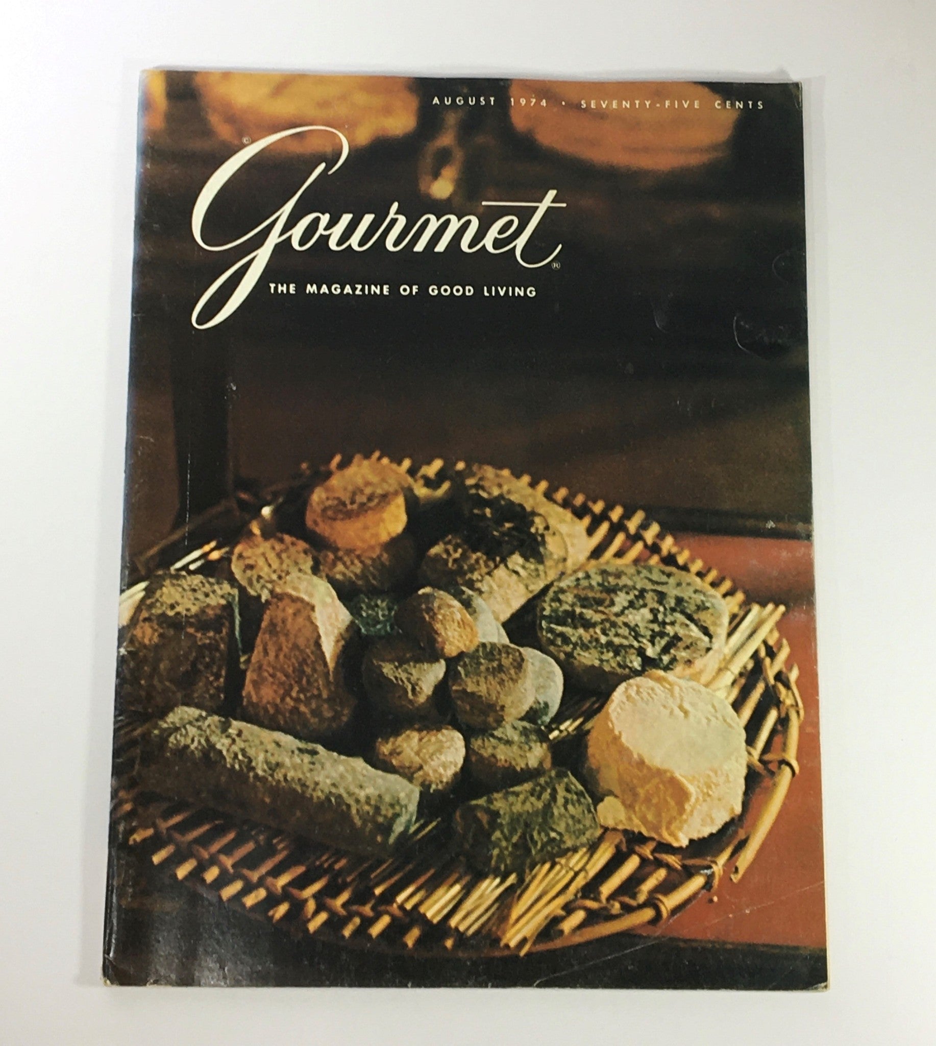 Cover of VTG Gourmet: The Magazine of Good Living August 1974 showcasing an artistic arrangement of gourmet delicacies on a woven basket, enhancing the vintage culinary aesthetic.