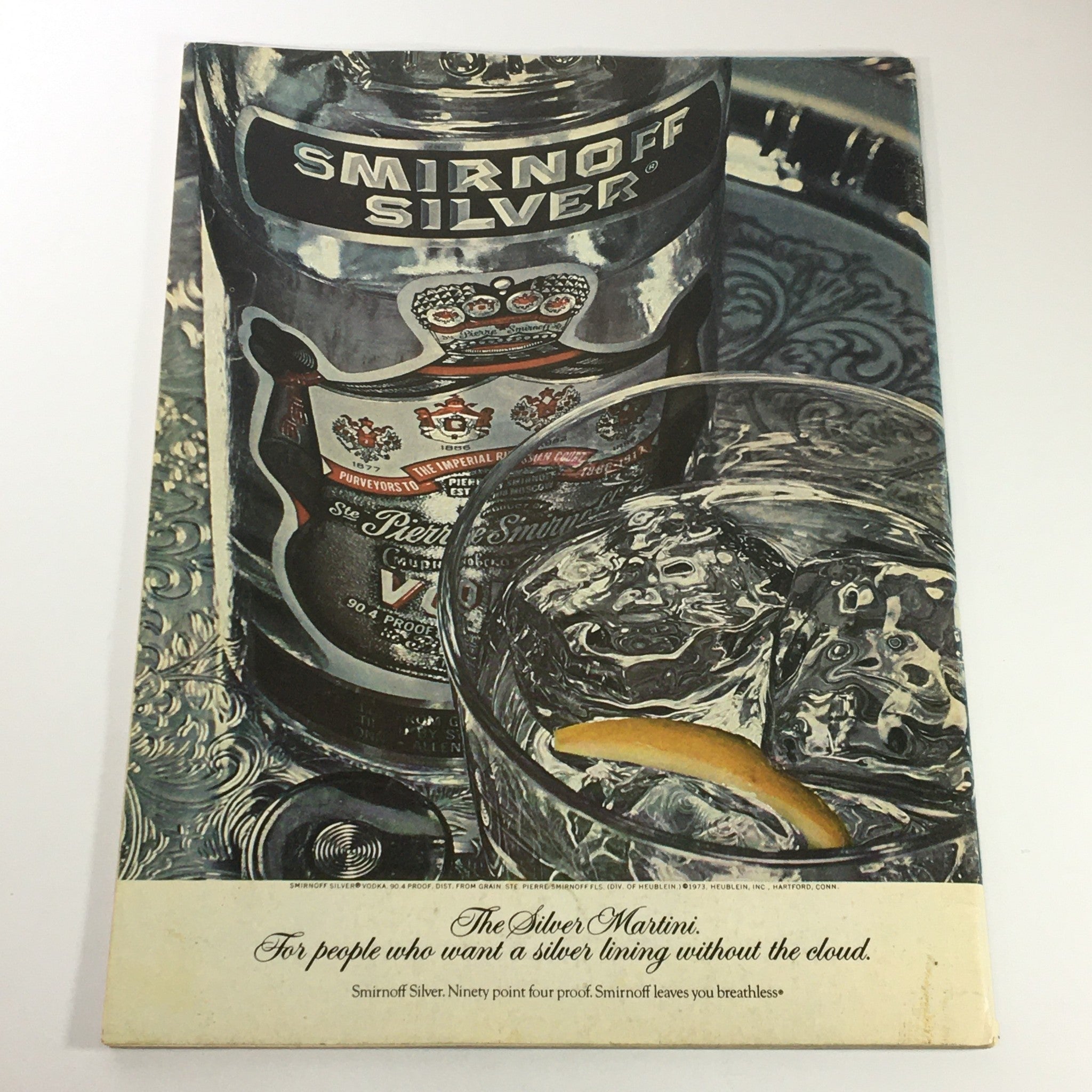Back cover of VTG Gourmet: The Magazine of Good Living August 1974 featuring an advertisement for Smirnoff Silver, illustrating a stylish cocktail glass with ice and a lemon slice, capturing the essence of sophisticated dining.