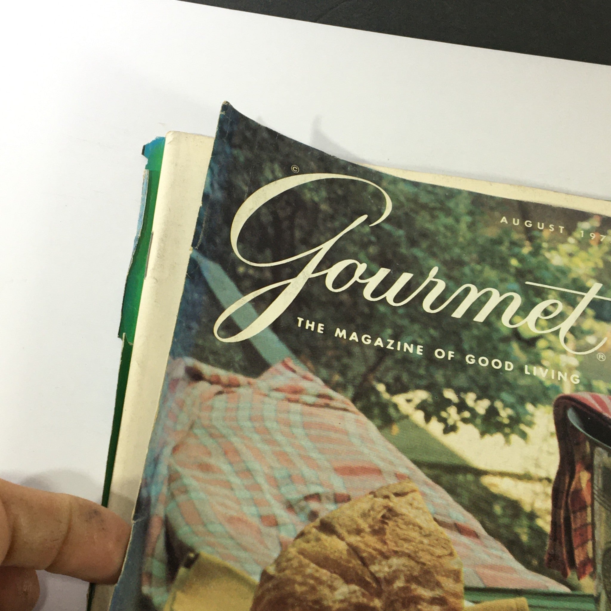 Close-up view of the cover of VTG Gourmet The Magazine of Good Living August 1975 featuring the publication's title and a bread roll.