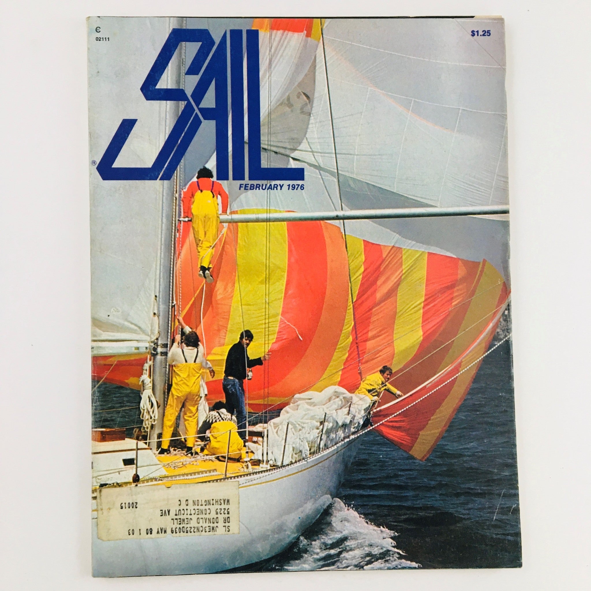 Sail Magazine February 1976 cover featuring colorful spinnaker sails on the sloop Aoranji with crew members engaged in acrobatics on deck.