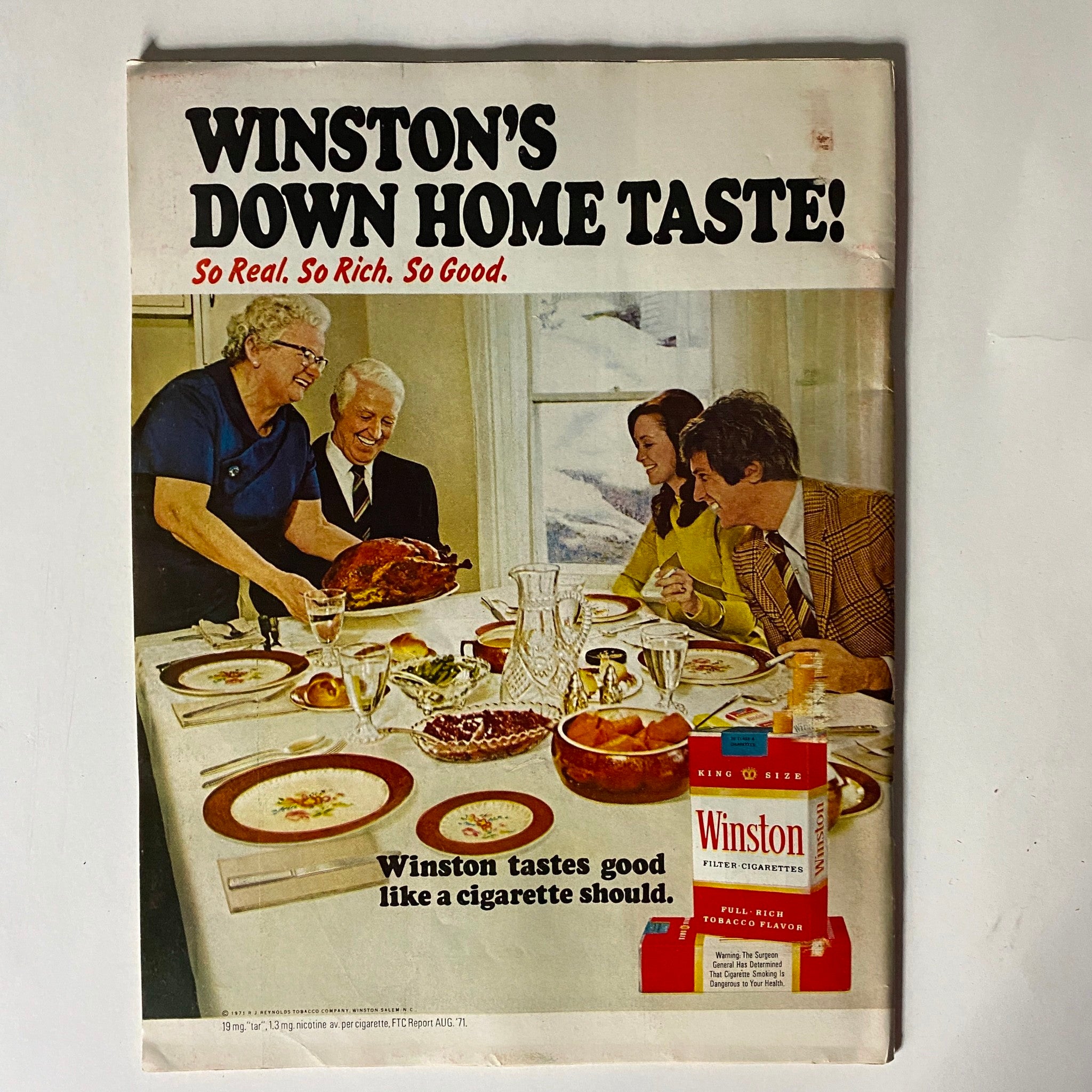 Winston's advertisement from the 1970s showcasing a family gathering around a dining table with a turkey, promoting Winston cigarettes with the slogan 'Winston tastes good like a cigarette should.'