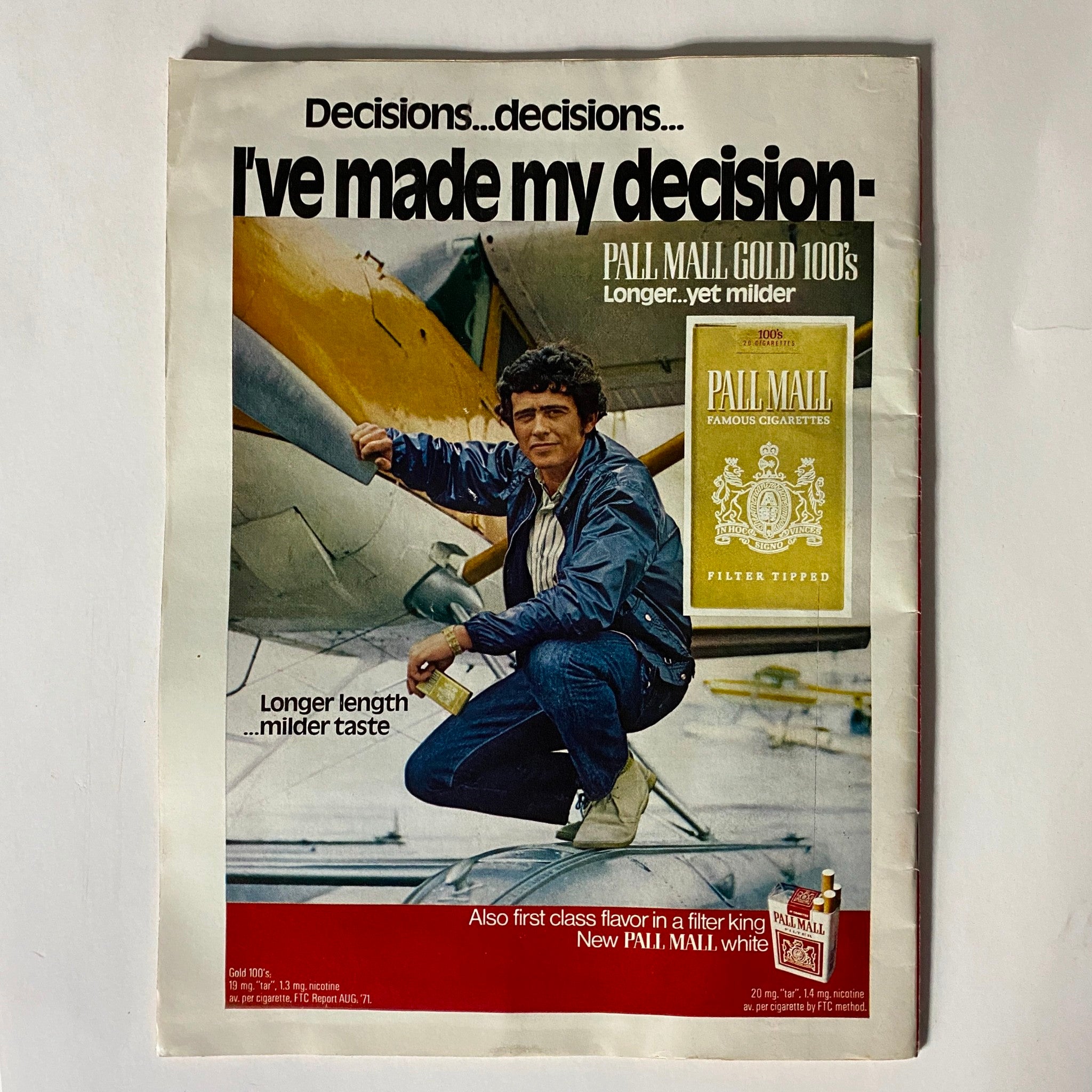 Vintage advertisement for Pall Mall cigarettes featuring a man in casual attire standing next to an airplane, promoting 'Pall Mall Gold 100s' with the tagline 'Longer...yet milder'.
