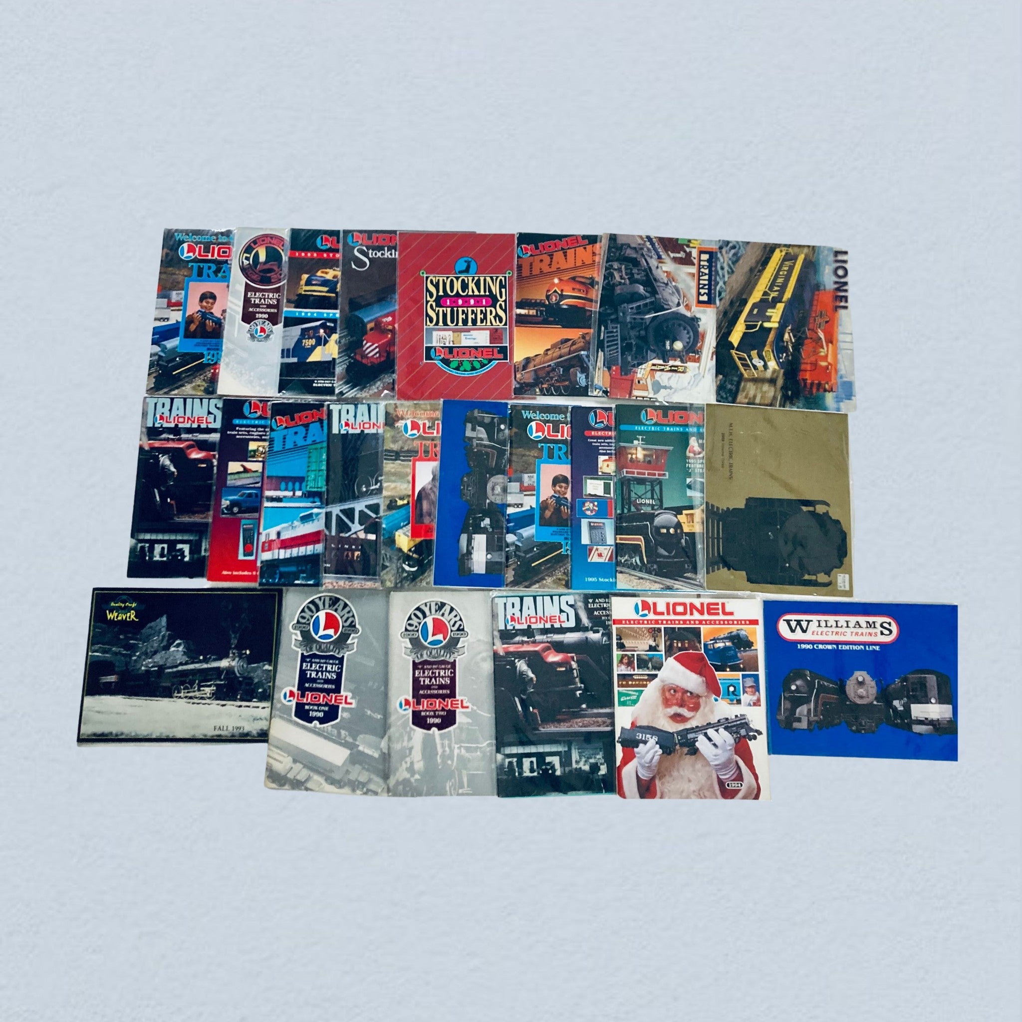 Lot of 24 1990s Lionel Electric Trains and Accessories Catalog, featuring a collection of colorful train catalogs and magazines from the 1990s, showcasing various electric trains and accessories.