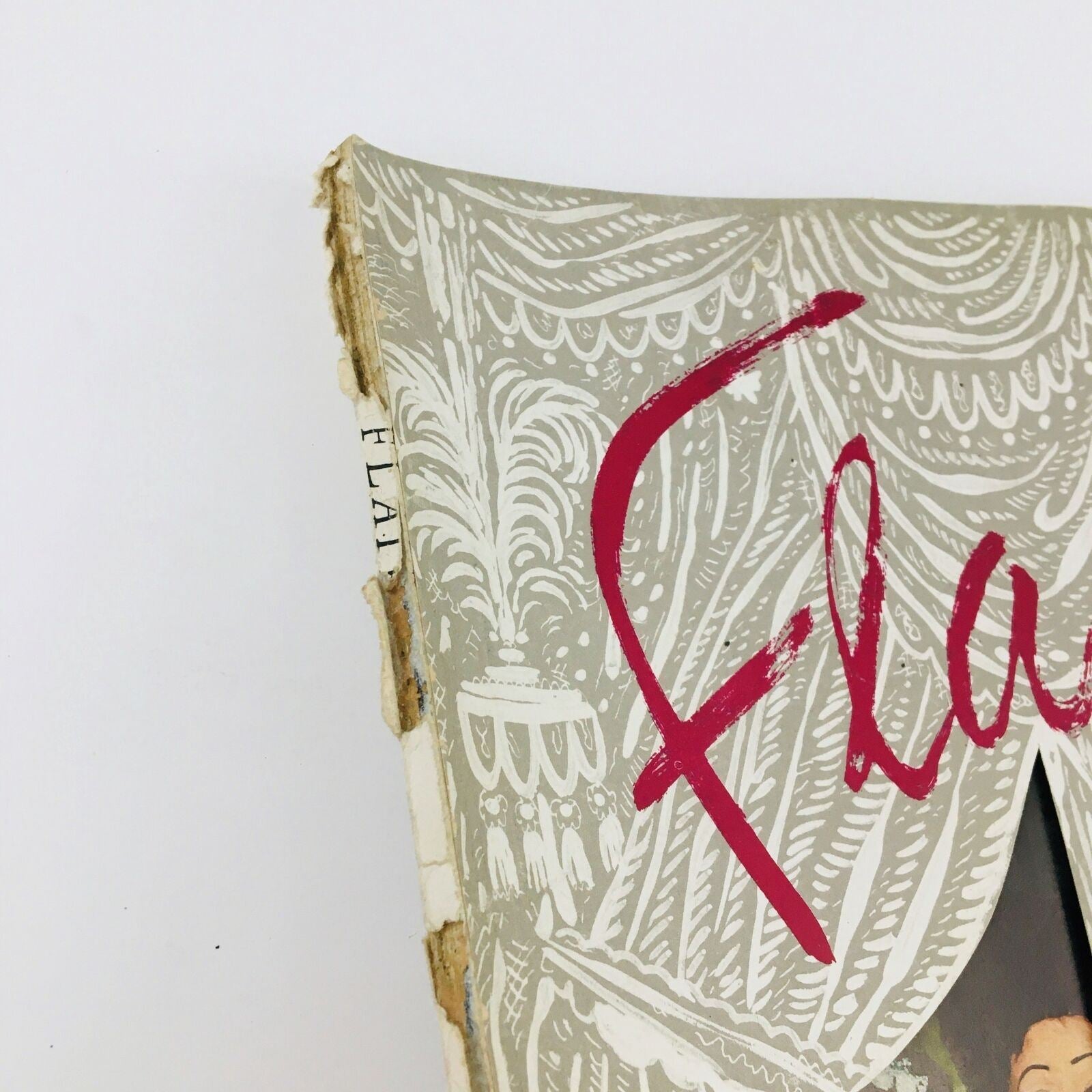 Side view of the worn edge of the VTG Flair Magazine October 1950 Vol. 1 No. 9, highlighting the intricate cover design.