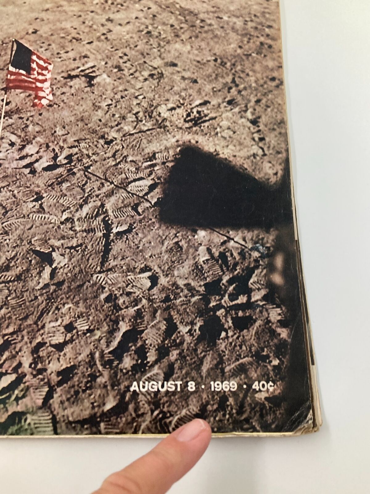 Close-up of the edge of VTG Life Magazine August 8 1969, showing the date and details about the moon landing with visible footprints.
