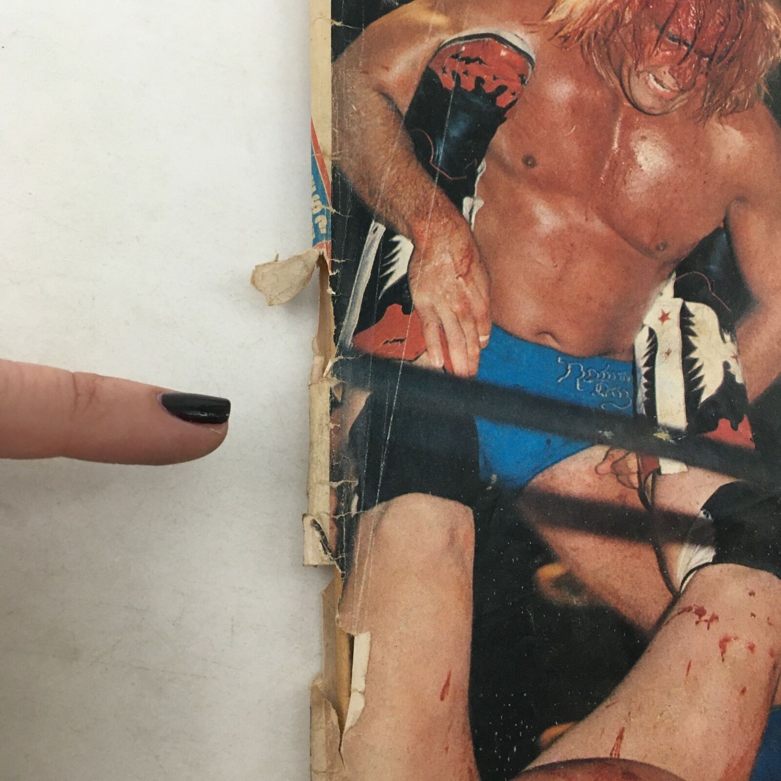Close-up view of the spine of The Wrestler Magazine November 1978, showing wear and tear indicating its vintage condition, featuring wrestlers in a tag team match.