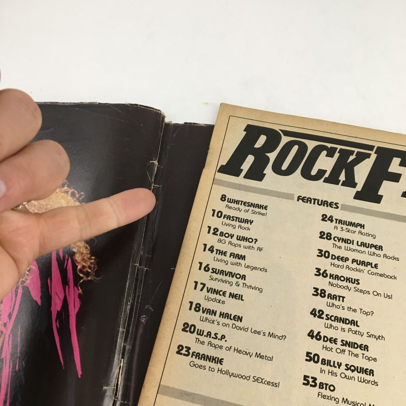 Close-up of the contents page from Rock Fever Magazine June 1985 Vol 2 #2 with a hand gesture, highlighting featured articles on prominent rock artists and bands.