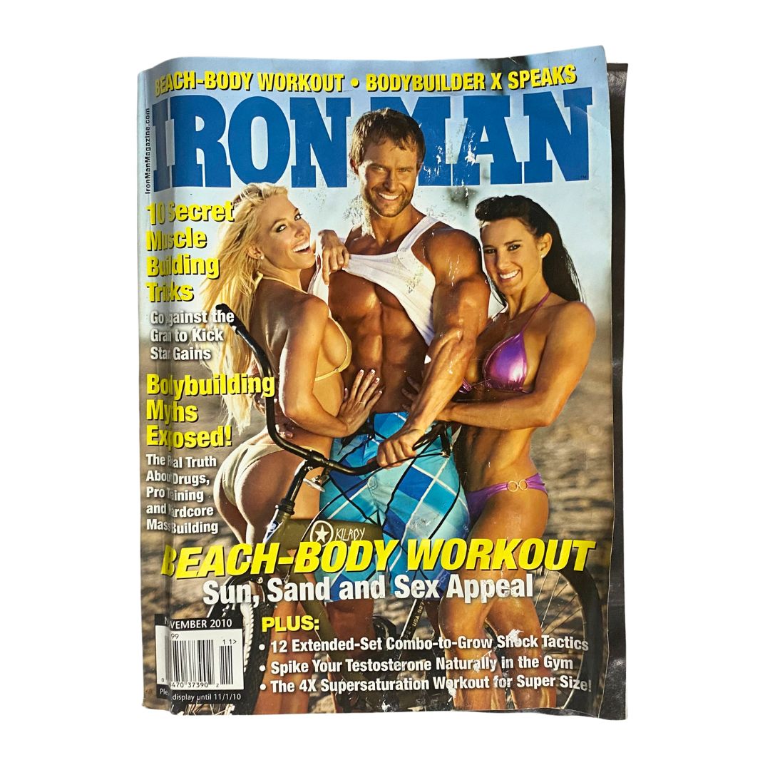 Iron Man Magazine November 2010 cover featuring a muscular male model with two female models in bikinis, showcasing fitness and beach body workout themes.
