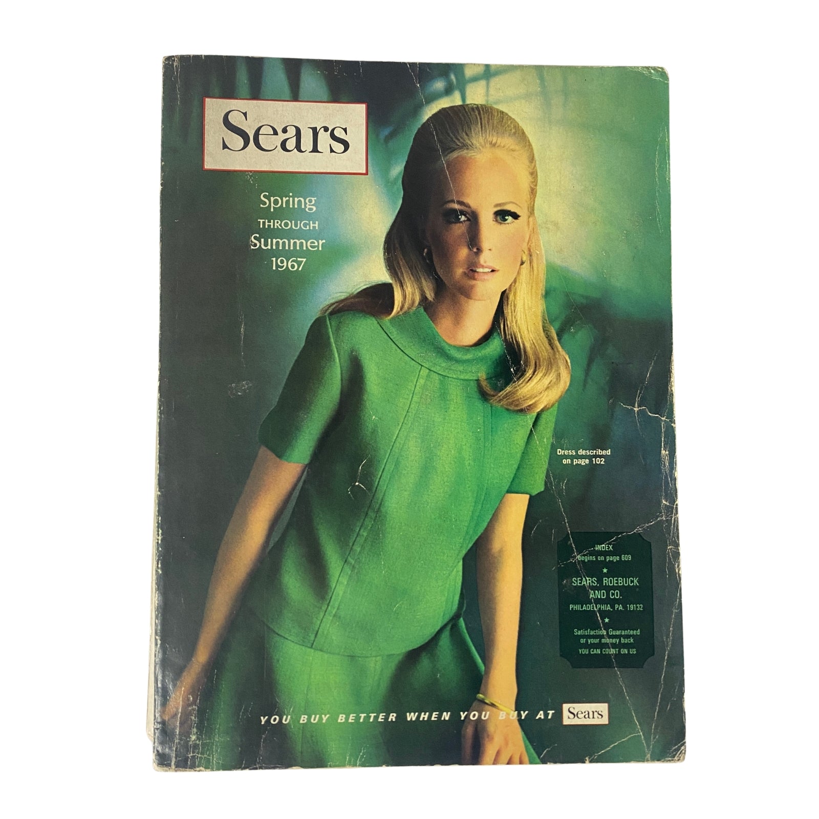 Cover of the 1967 Sears Spring Through Summer Catalog featuring a model in a vibrant green dress, showcasing mid-century fashion and style from the 1960s.