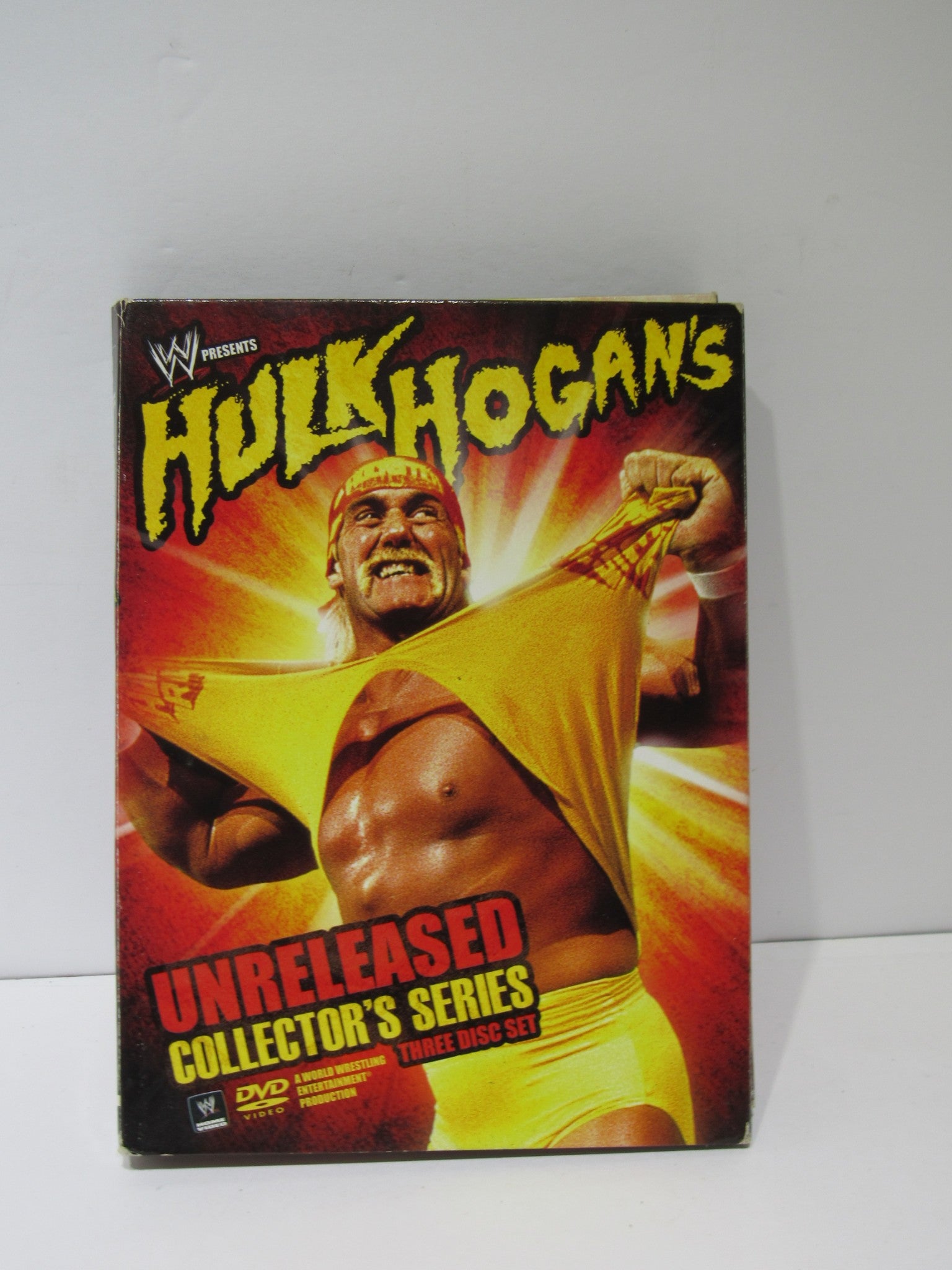 Hulk Hogan's Unreleased Collector's Series (2009) DVD cover featuring Hulk Hogan in a yellow outfit bursting through a background of explosive colors.