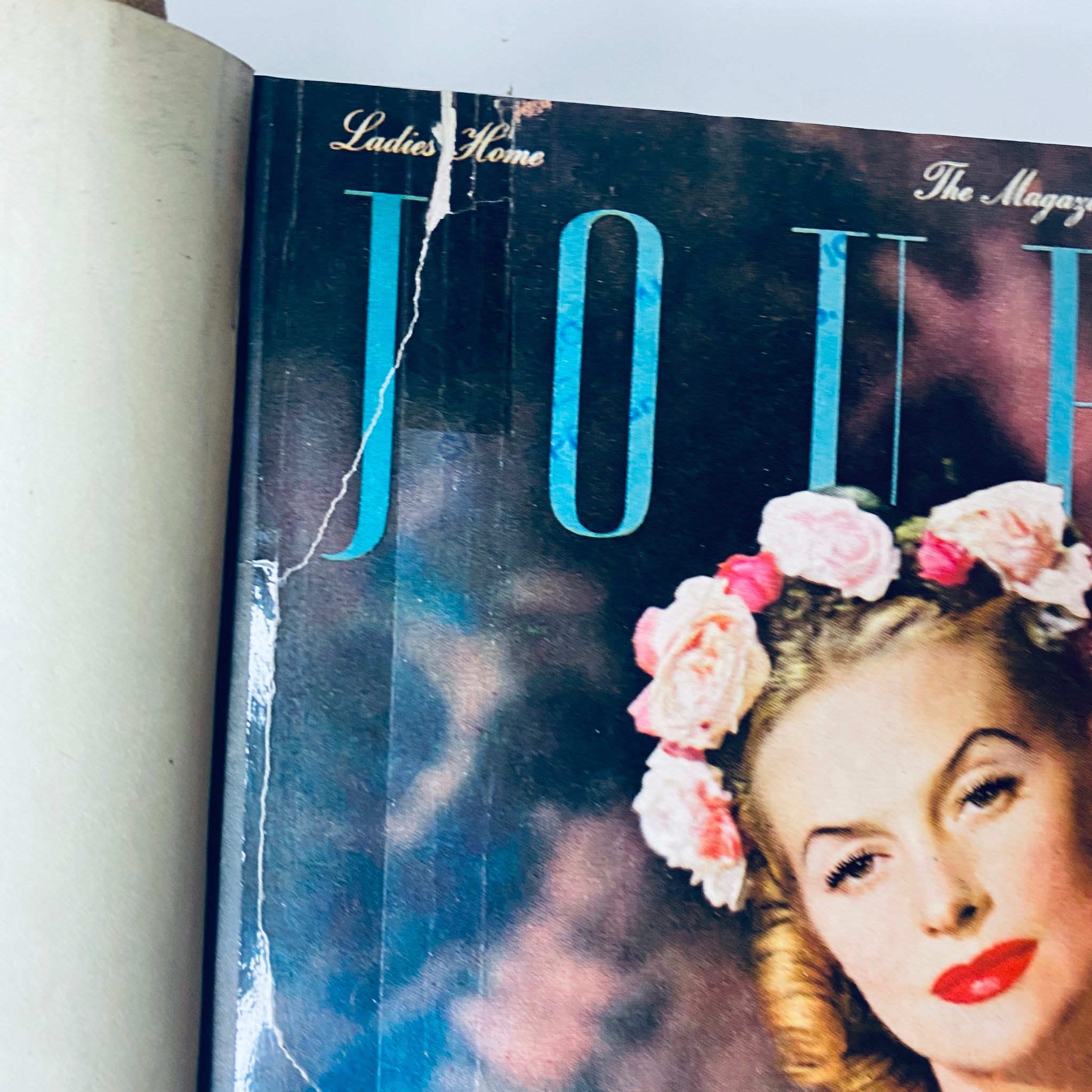 Close-up of the cover of Ladies' Home Journal January 1946, focusing on the woman's portrait adorned with flowers, capturing the fashion of the era.