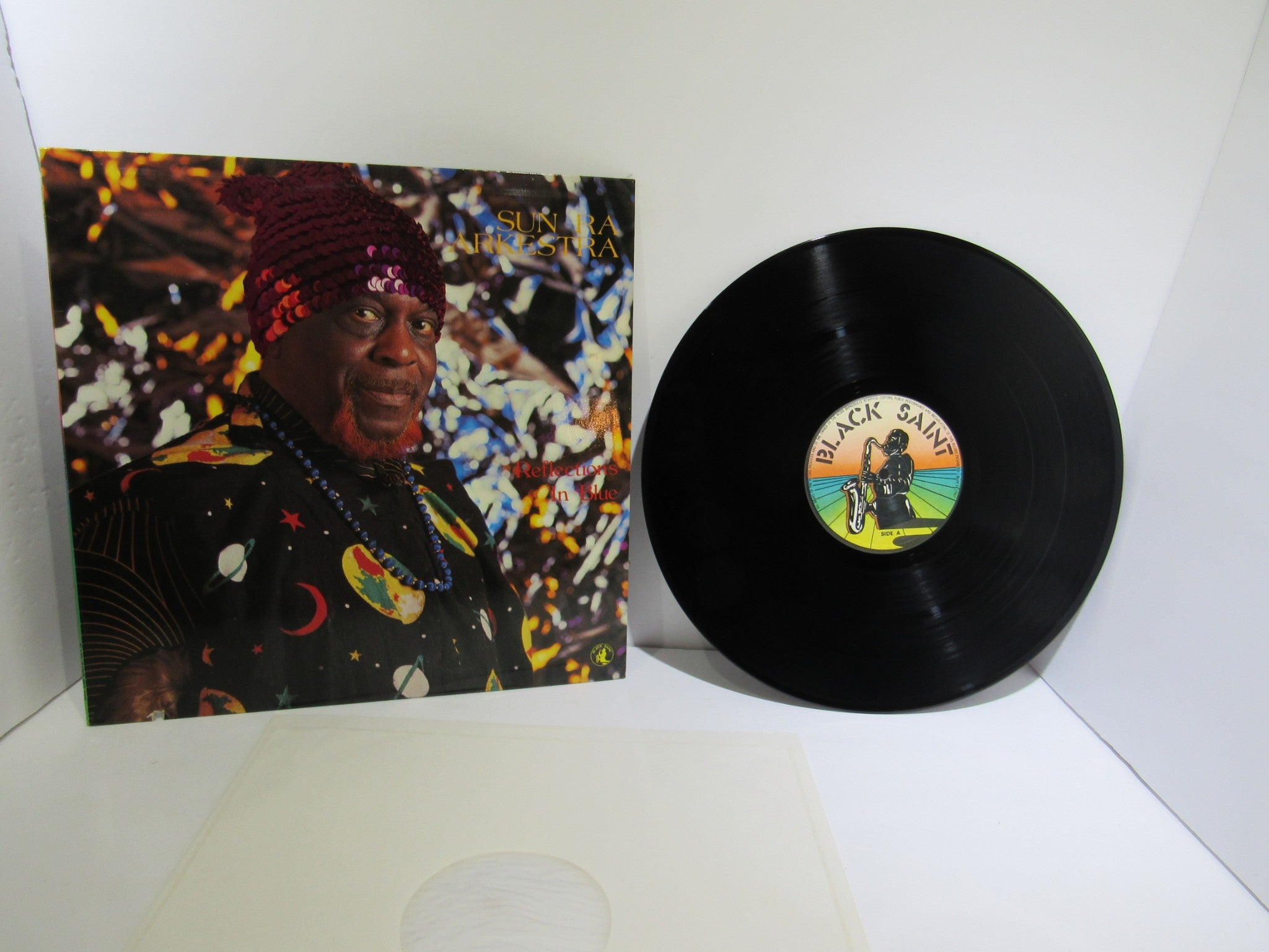 Sun Ra Arkestra: Reflections In Blue Black Saint BSR 0101 LP displayed with the record and cover art in view, showcasing vibrant colors and design.
