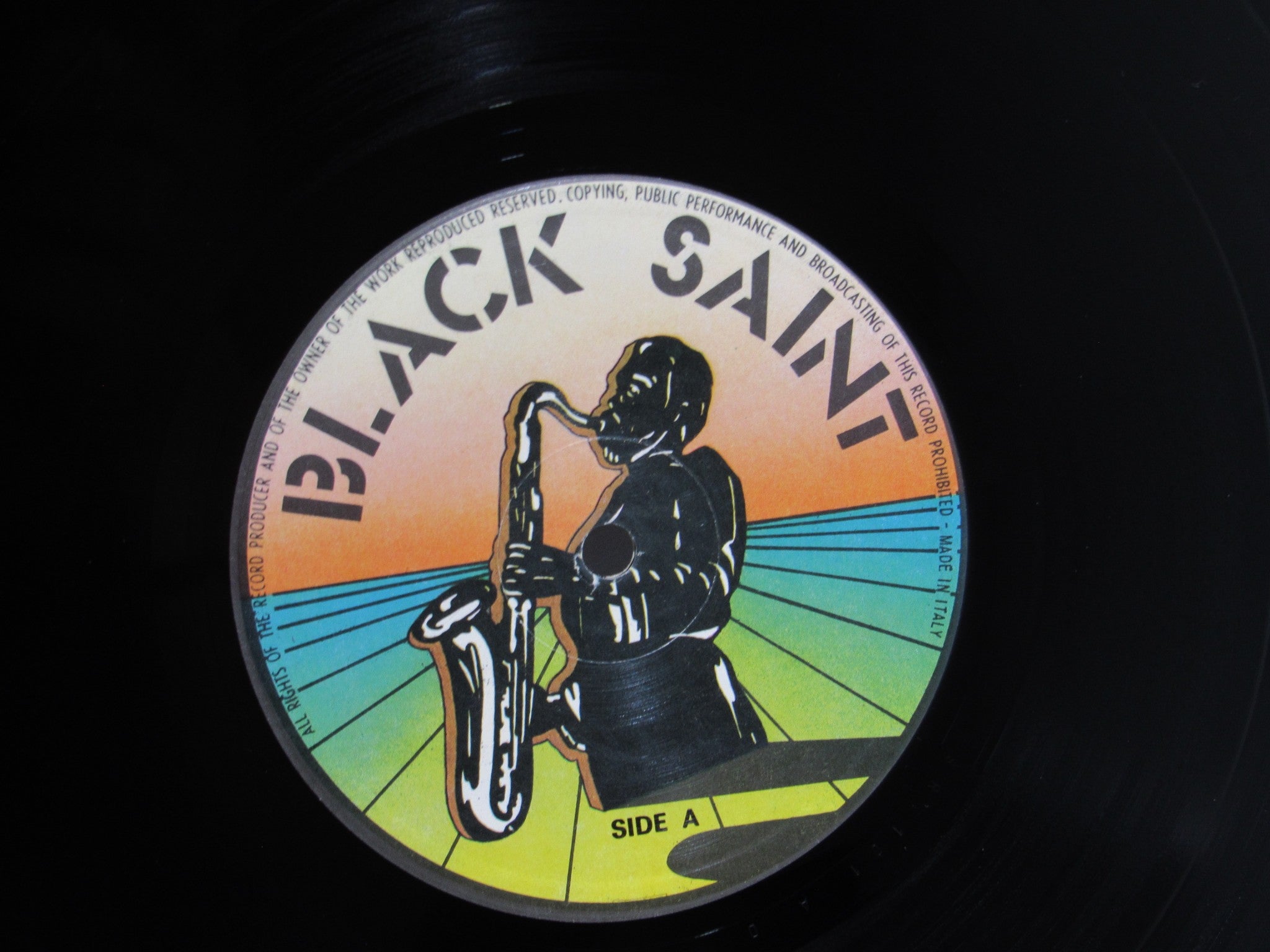 Close-up of the Black Saint vinyl record label from Sun Ra Arkestra: Reflections In Blue showcasing saxophonist artwork and vibrant color scheme.