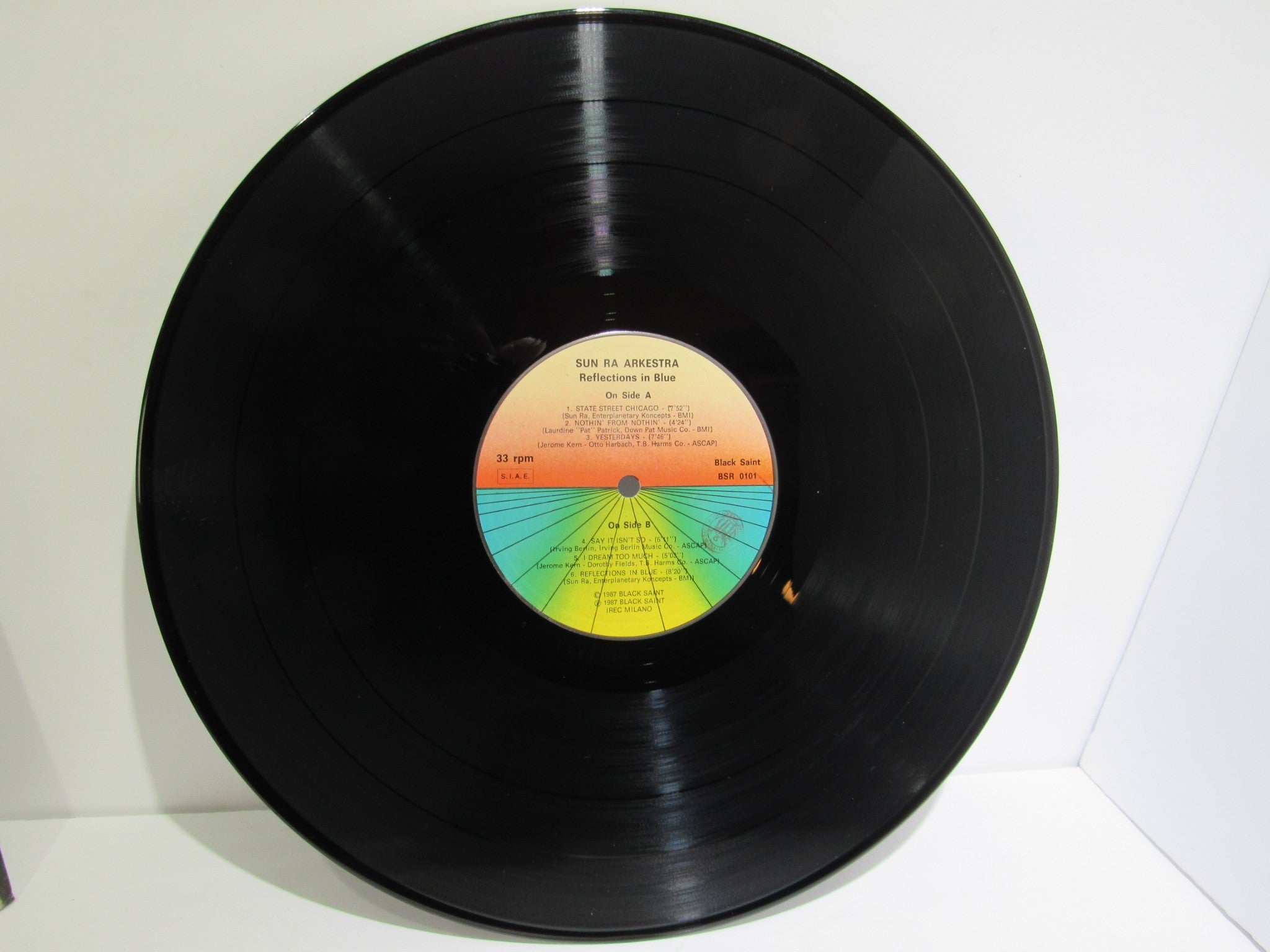 Back view of Sun Ra Arkestra: Reflections In Blue Black Saint BSR 0101 LP illustrating the colorful record label details and track listing.