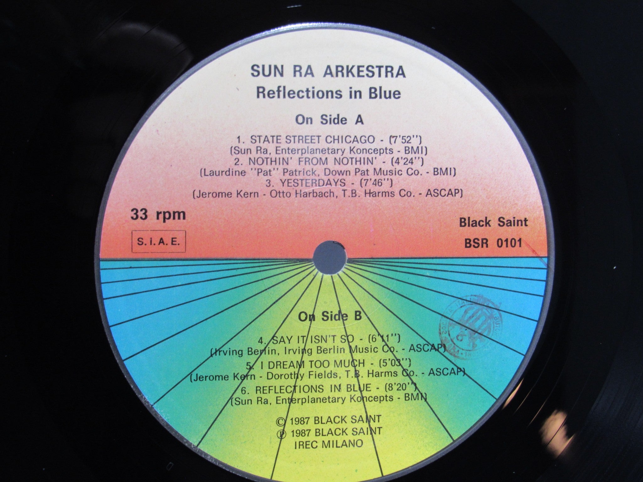 Close-up of the label on the vinyl record 'Sun Ra Arkestra: Reflections In Blue Black Saint BSR 0101', displaying song titles and artist details.