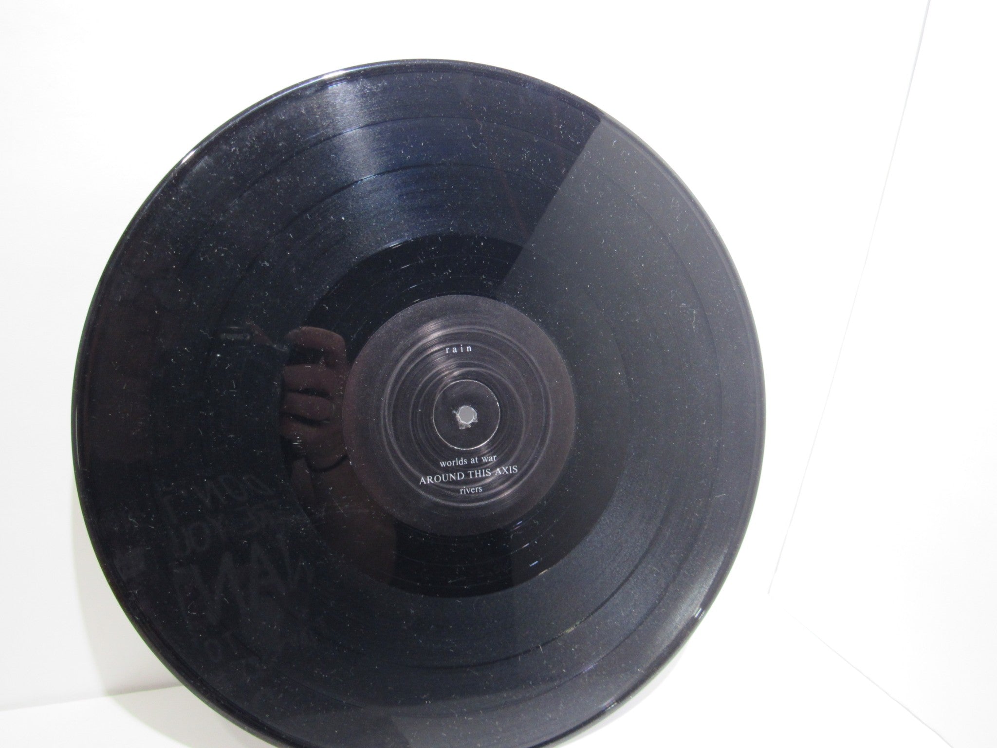 Vinyl record label of 'Rain La Vache Qui Rit Peterbilt Records Peterbilt 3 1990 Rock LP Grade: VG', showcasing the title 'worlds is is' and song 'AROUND THIS AXIS'.