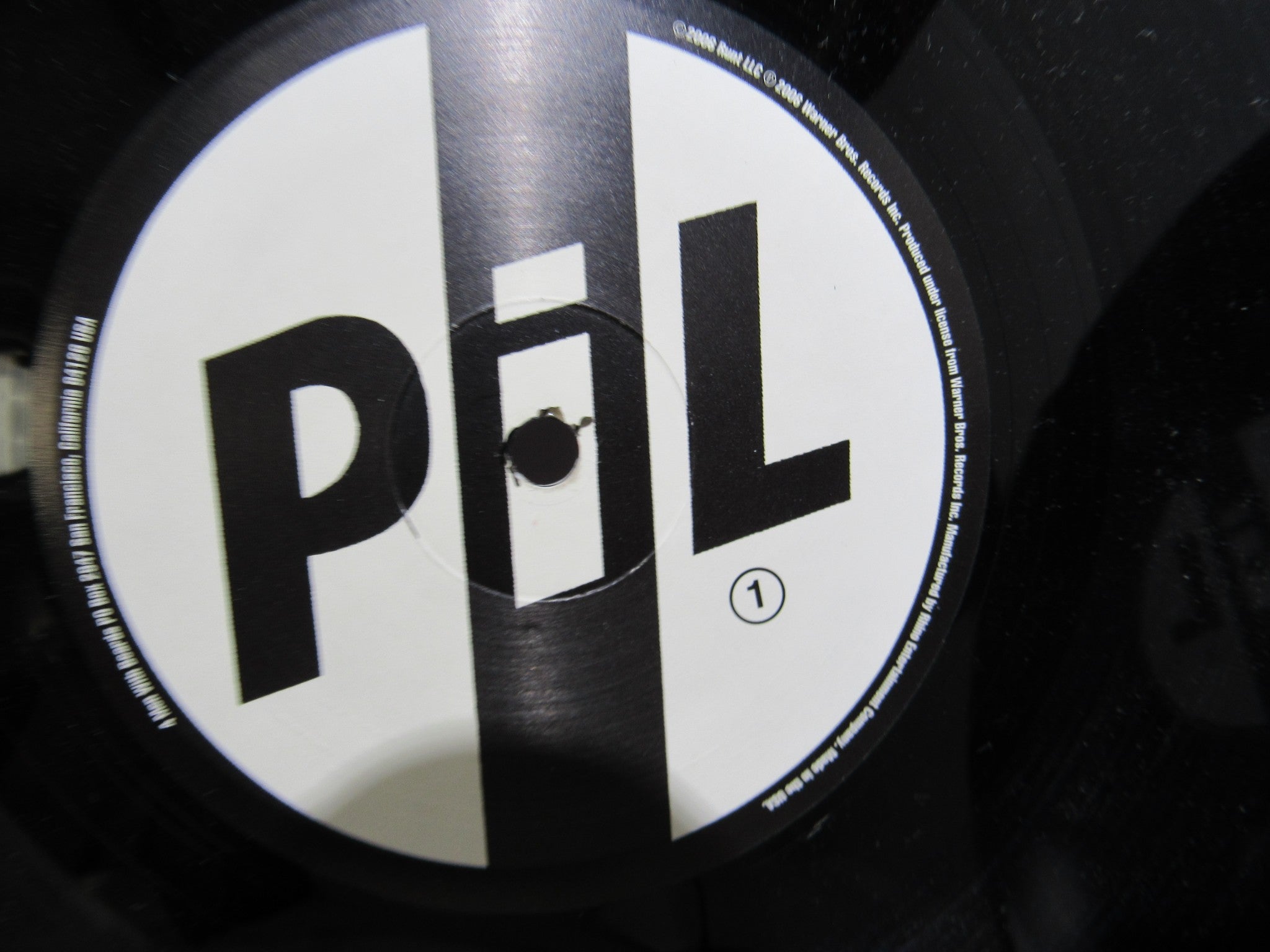 Detail of the first side label of a Public Image Limited vinyl record from the Metal Box 4 Men With Beards ‎– 4M 500 collection, showing the distinctive logo and information.