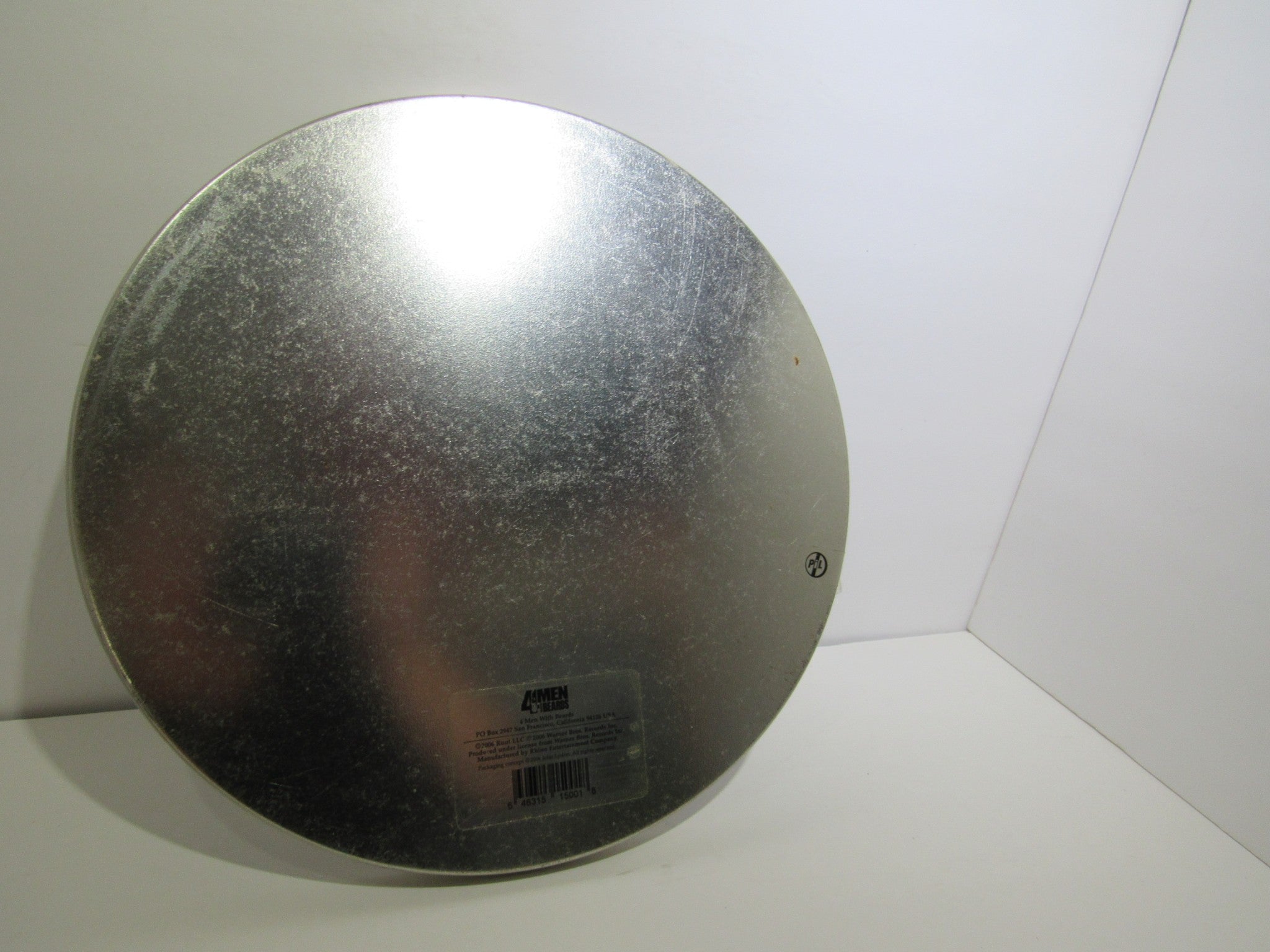 Photo of the underside of the metal box for Public Image Limited Metal Box 4 Men With Beards – 4M 500, illustrating the surface wear and features.