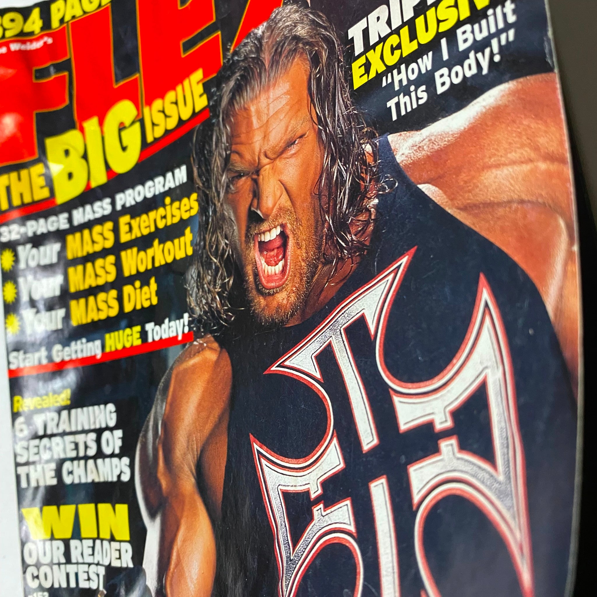 Close-up of Joe Weider's Flex Magazine July 2002 cover showcasing Triple H, emphasizing his muscular physique and the magazine's title, FLEX, at the top.