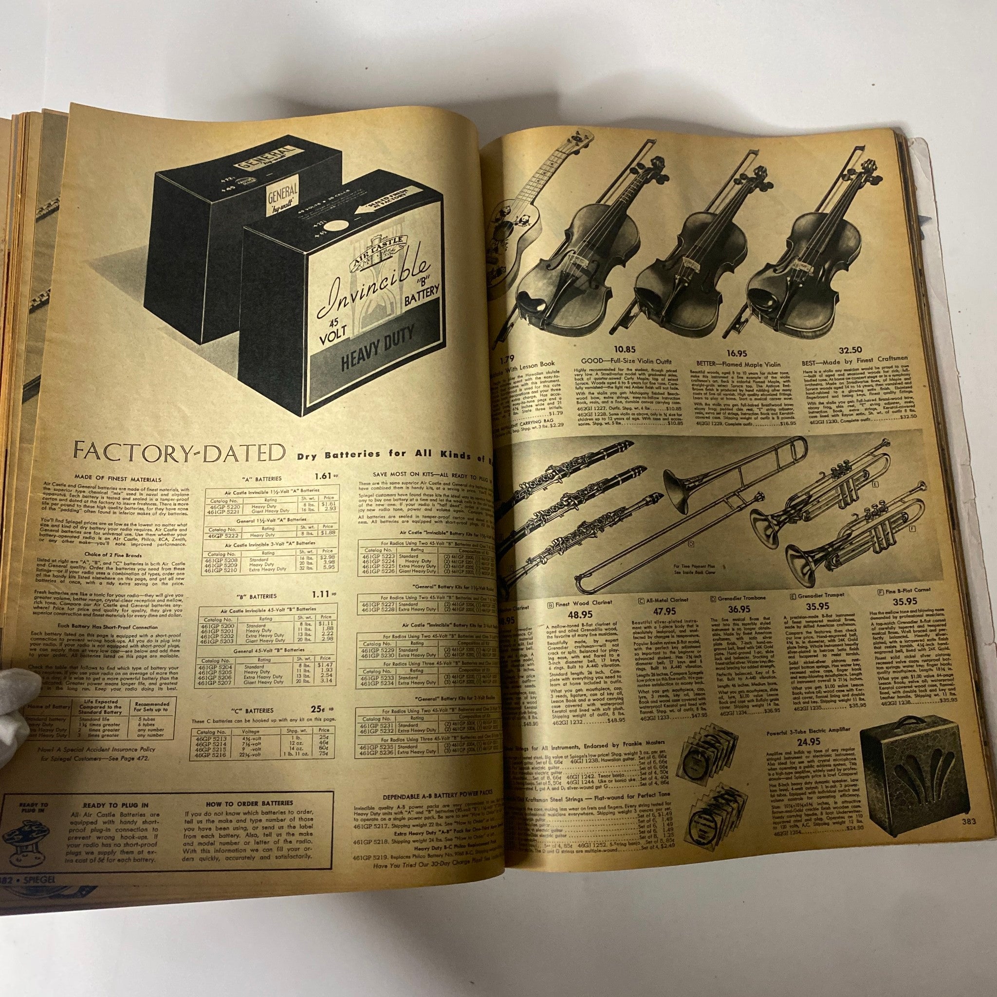 Interior page from the 1943 Spiegel Spring and Summer Catalog showcasing battery products and musical instruments, reflecting mid-20th-century American consumer culture.