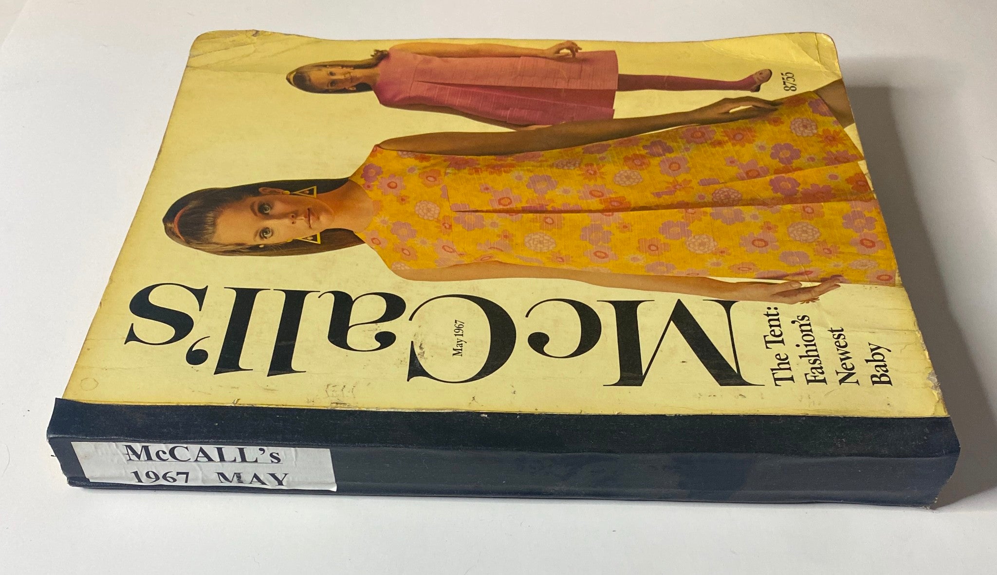 Side view of the 1967 May McCall's New York Designers' Collection catalog displaying the title and 'McCall's 1967 May' along with the models in vibrant dresses featured on the cover.