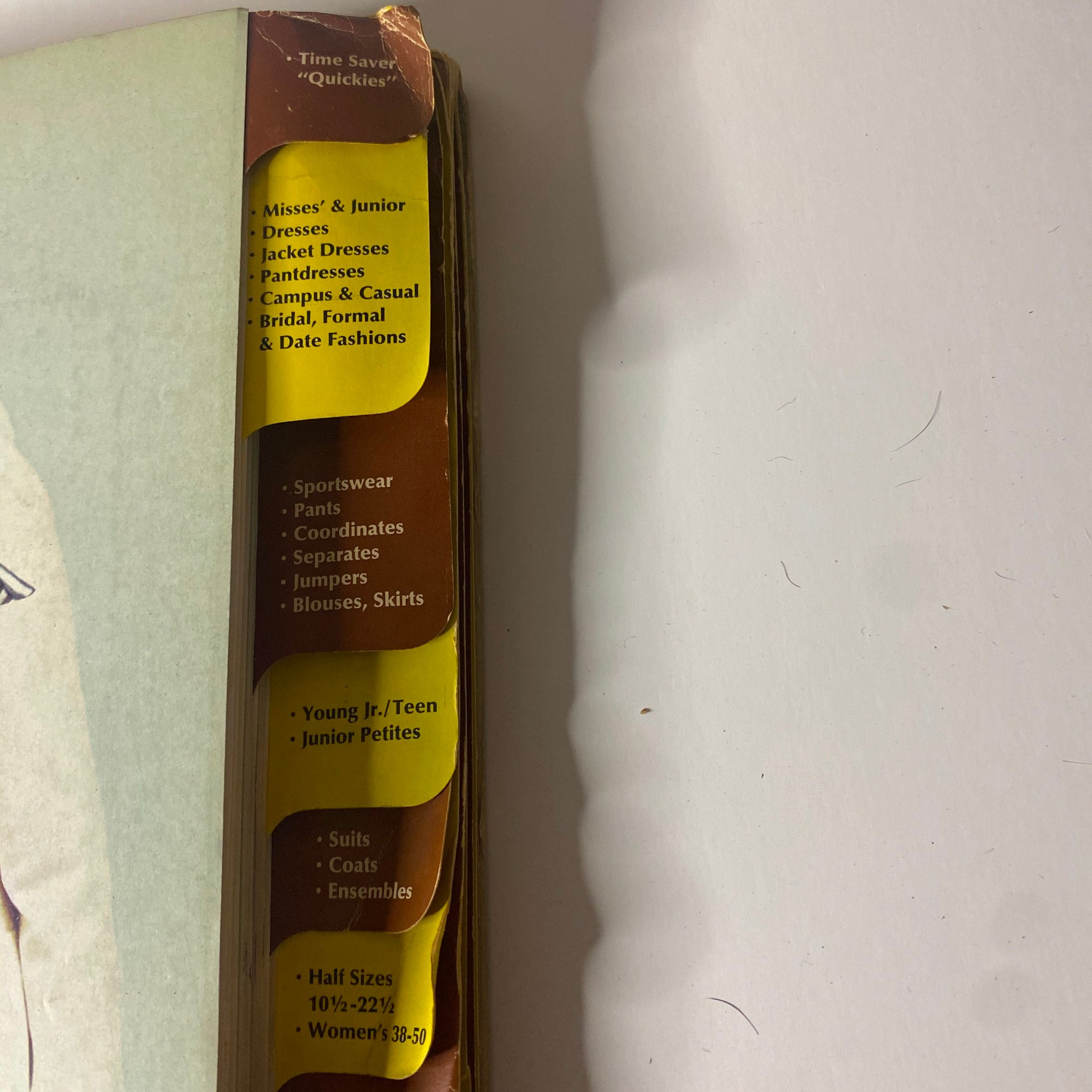 Spine view of the 1969 February McCall's Step by Step Patterns Catalog displaying categorized sections for various sewing patterns such as misses', juniors, and maternity.