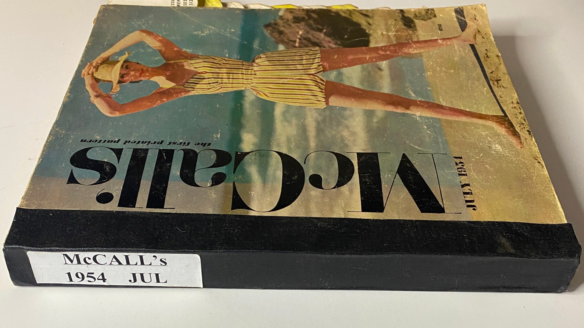 Bottom view of the 1954 July McCall's The First Printed Pattern Catalog, displaying its title and publishing details.