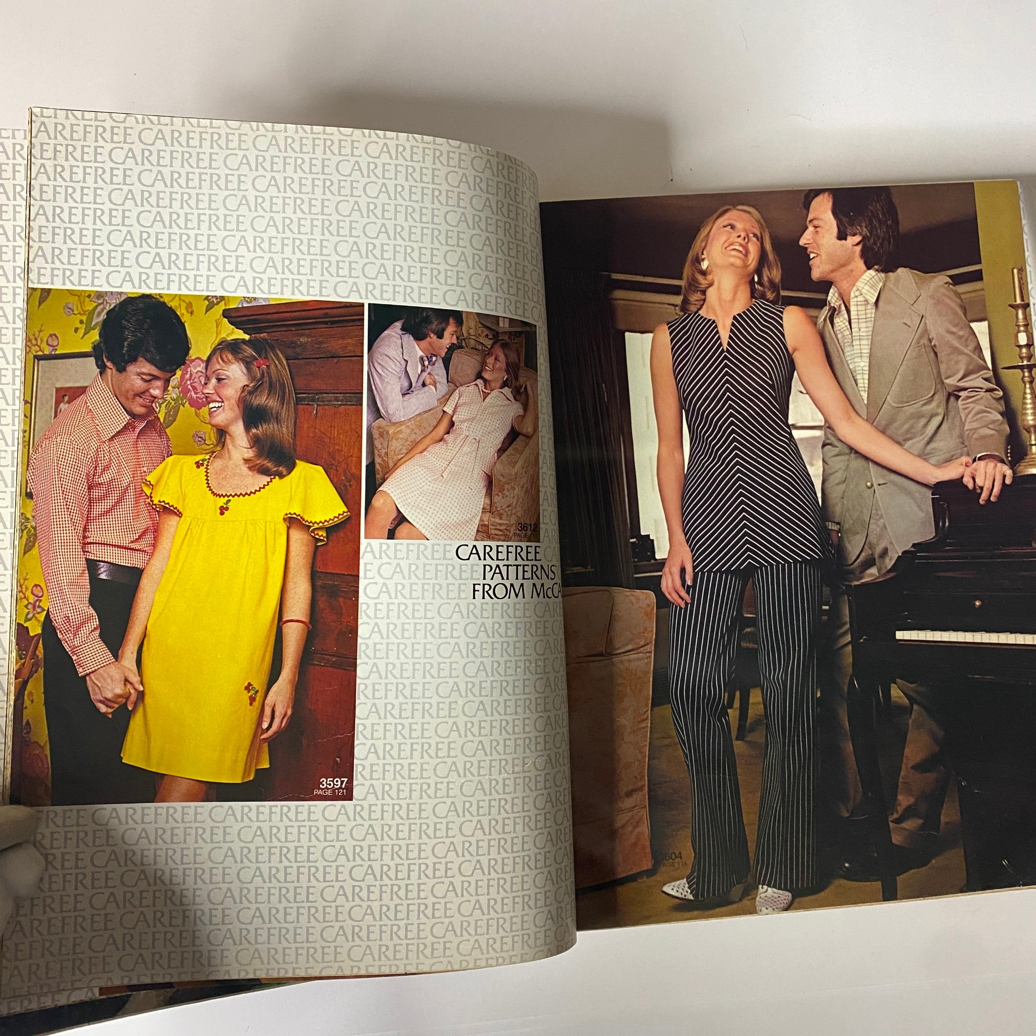 1973 July - August McCall's Carefree Patterns Catalog showcasing vibrant 1970s fashion. A couple poses with one in a yellow dress and the other in a striped outfit, highlighting playful summer styles.