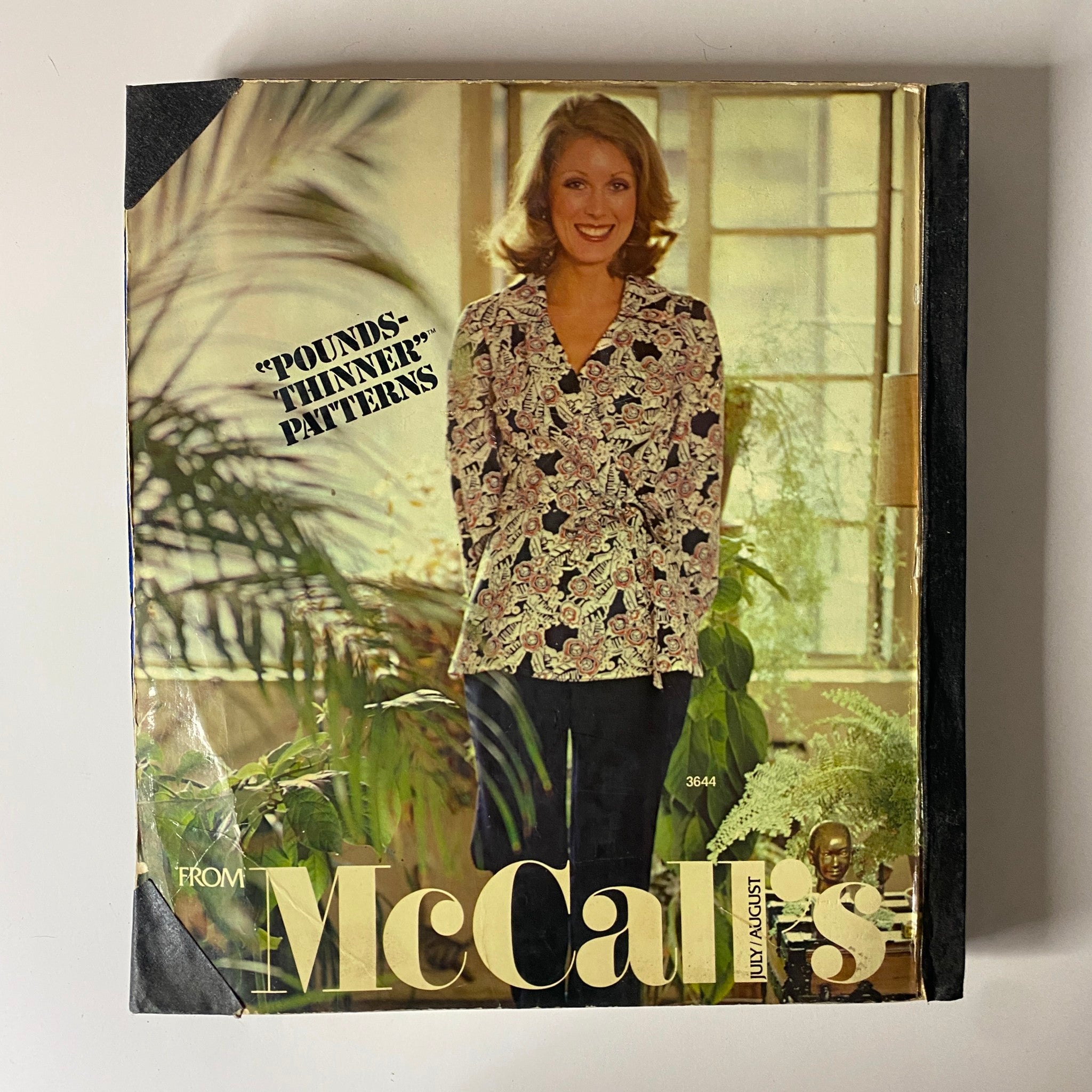 1973 July - August McCall's Carefree Patterns catalog cover featuring a woman in a floral wrap top and pants, conveying relaxed fashion from the early '70s.