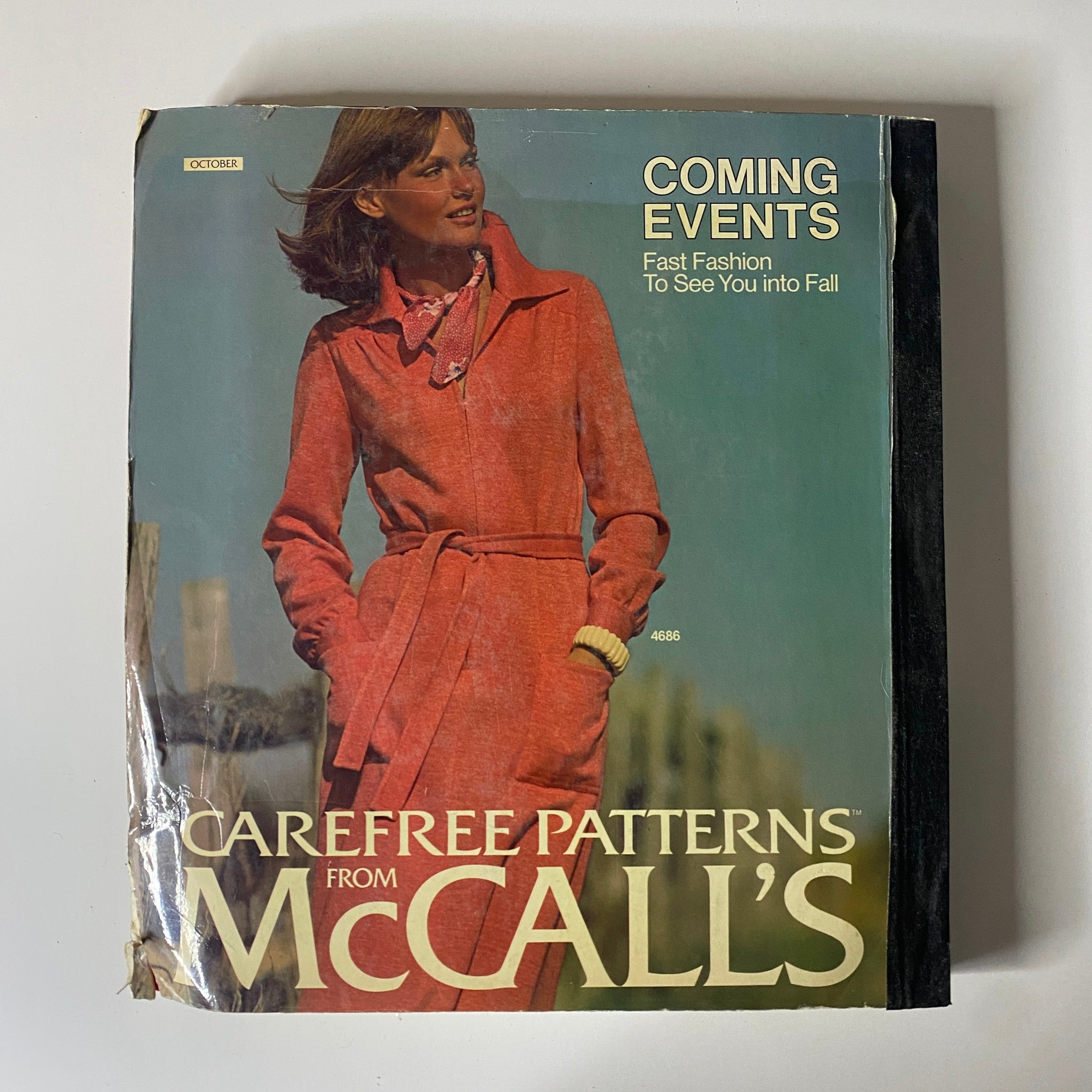 1975 October Carefree Patterns from McCall's Huge Store Retail Counter Catalog featuring a woman in a stylish red wrap coat, highlighting fall fashion trends from the mid-1970s.