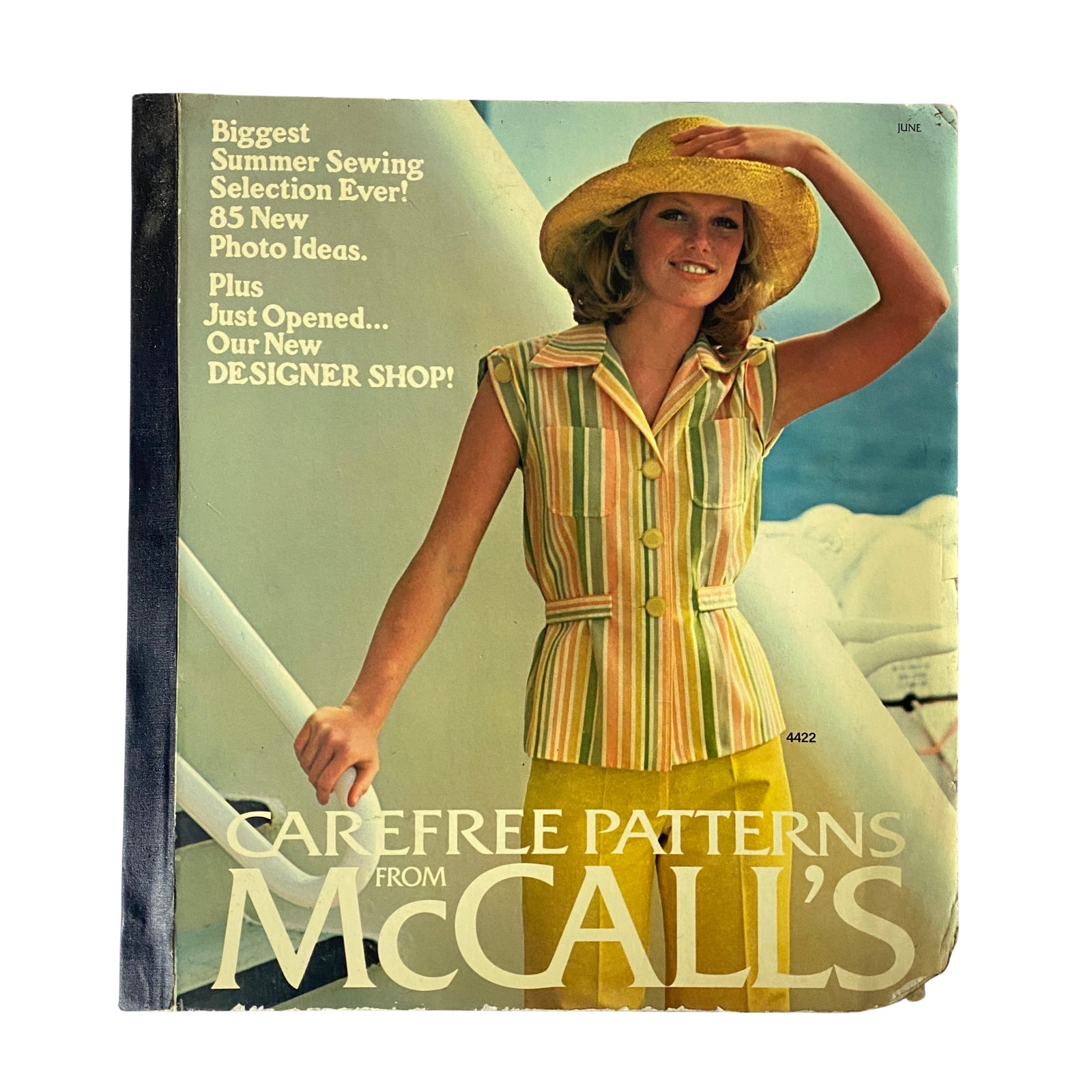 1975 June Carefree Patterns McCall's Catalog cover featuring a woman in a striped outfit and wide-brimmed hat, advertising summer sewing selections and designer shop openings.