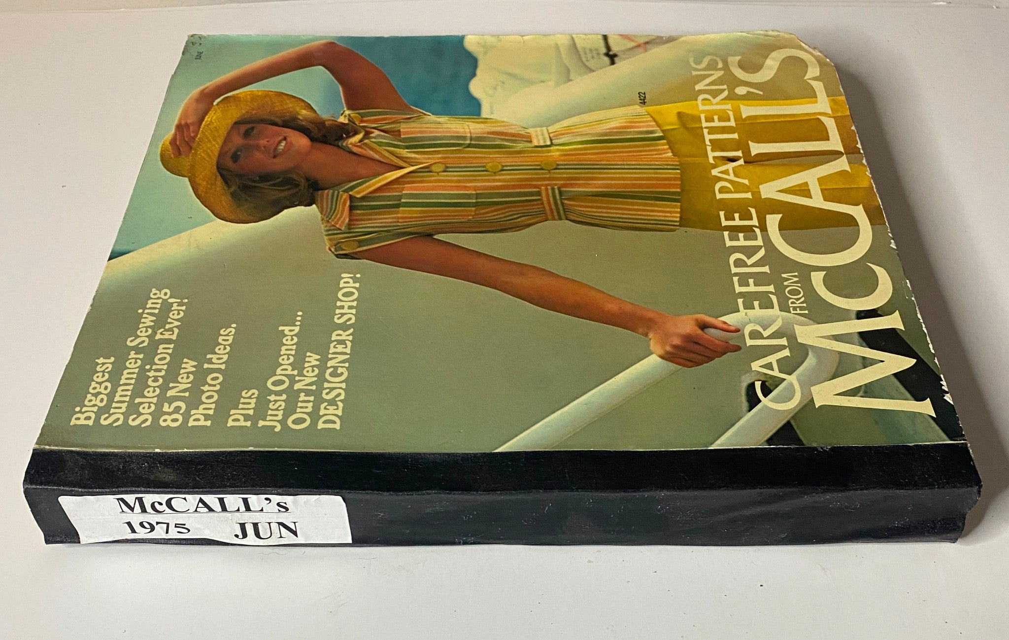1975 June Carefree Patterns McCall's Catalog side view showing the vibrant cover design with a woman in a summer outfit, indicating multiple photo ideas for sewing.