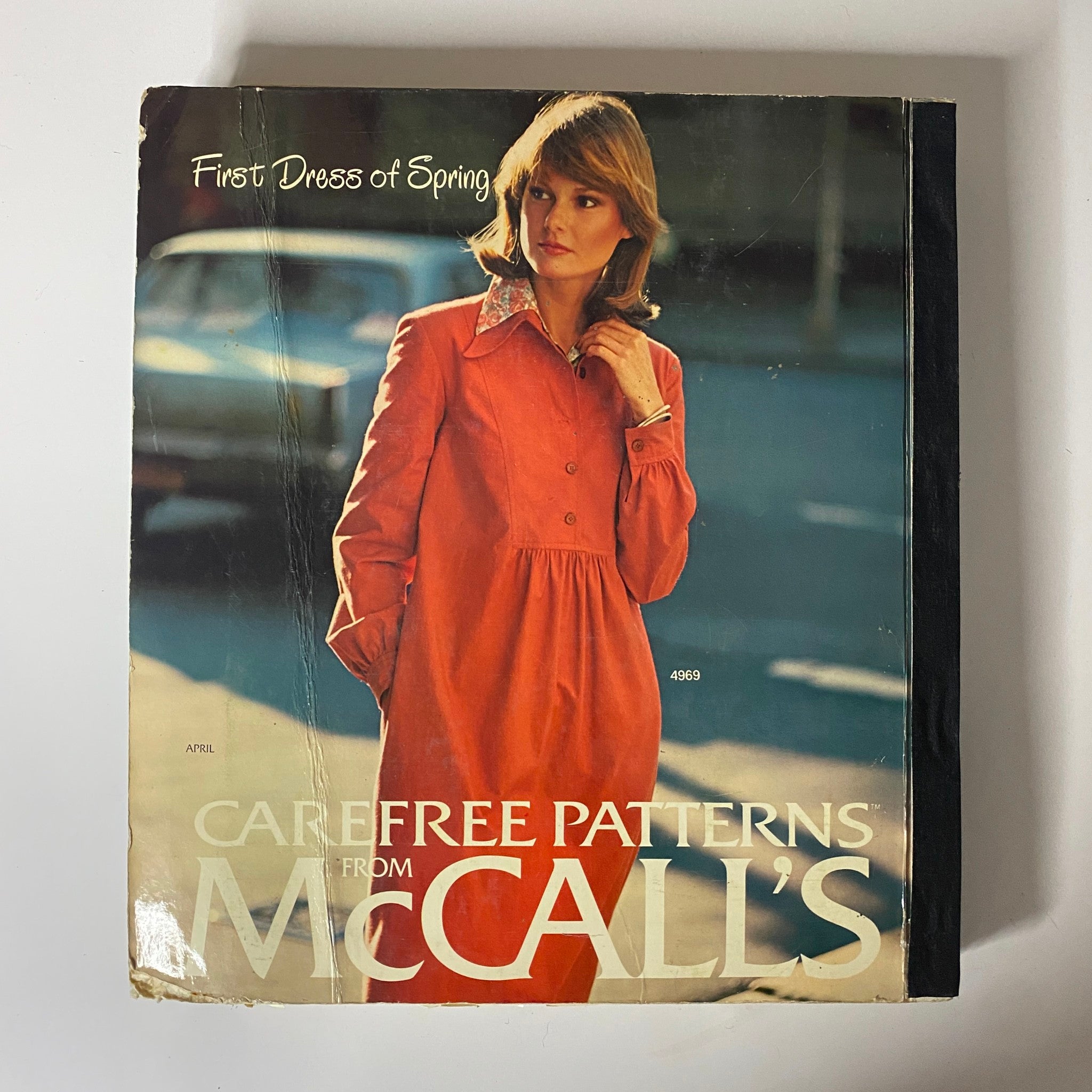1976 April Carefree Patterns McCall's Spring Catalog cover displaying a woman in a chic red dress, representing early spring fashion styles of the 1970s.
