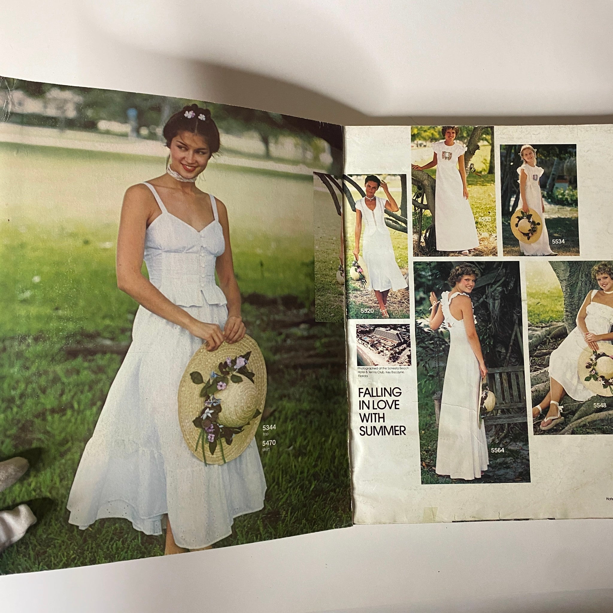 1970s June Carefree Patterns from McCall's catalog showcasing a woman wearing a white summer dress with a straw hat, emphasizing vintage summer fashion.